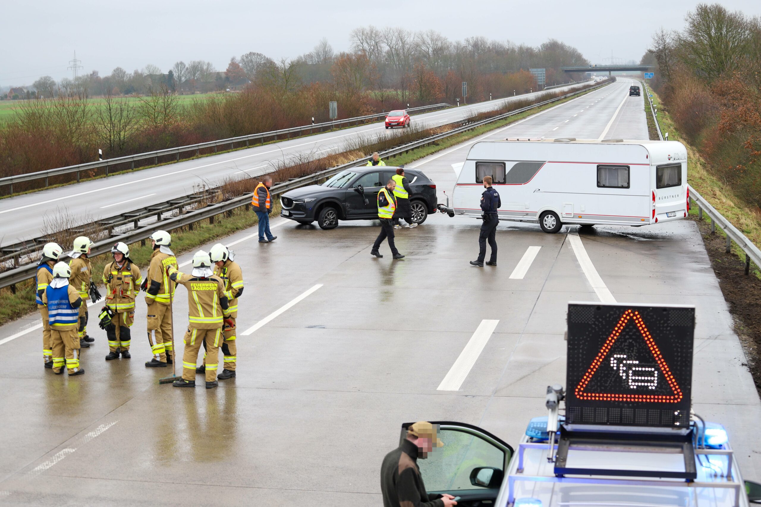 Einsatzkräfte vor dem Wohnwagen-Gespann.