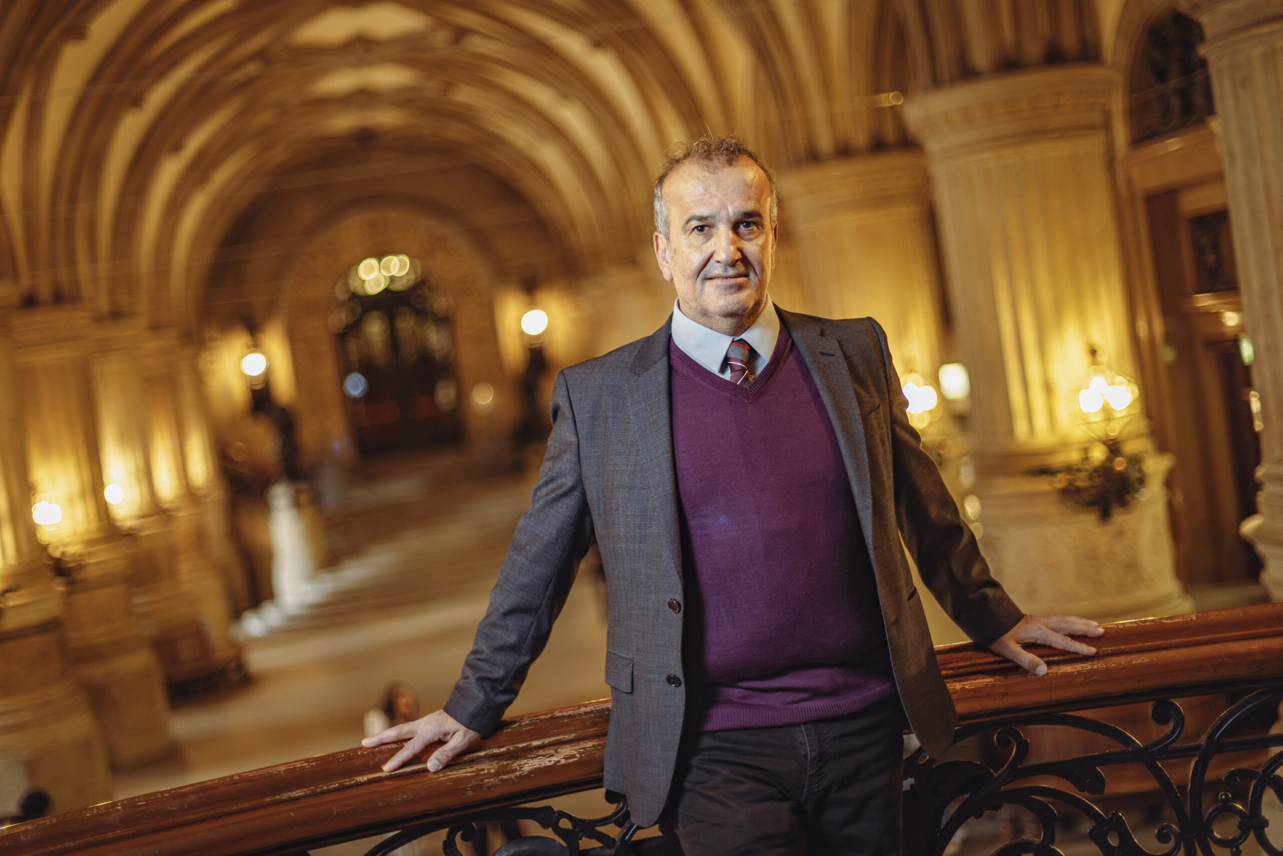 Kazim Abaci: Mann im Anzug vor Säulenhalle