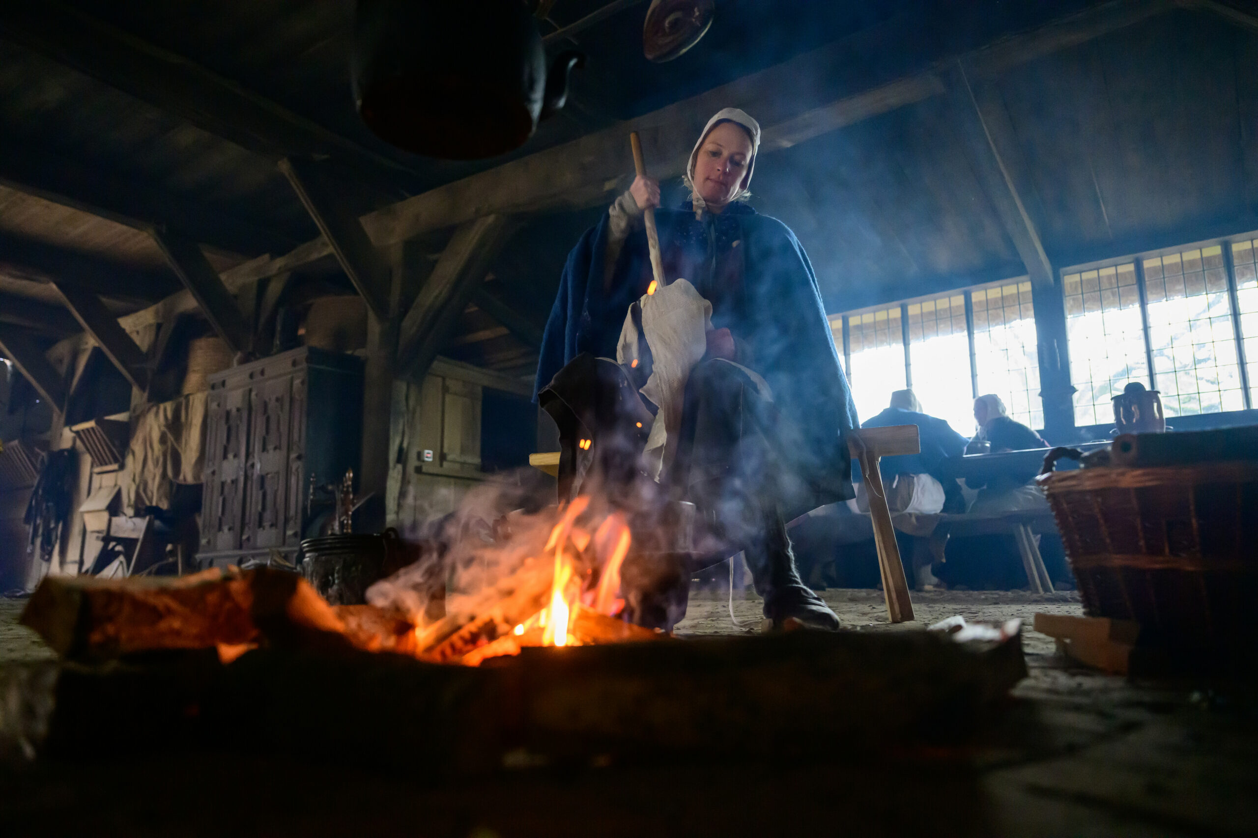 Eine ehrenamtliche Mitarbeiterin breitet Butter im Freilichtmuseum am Kiekeberg zu.