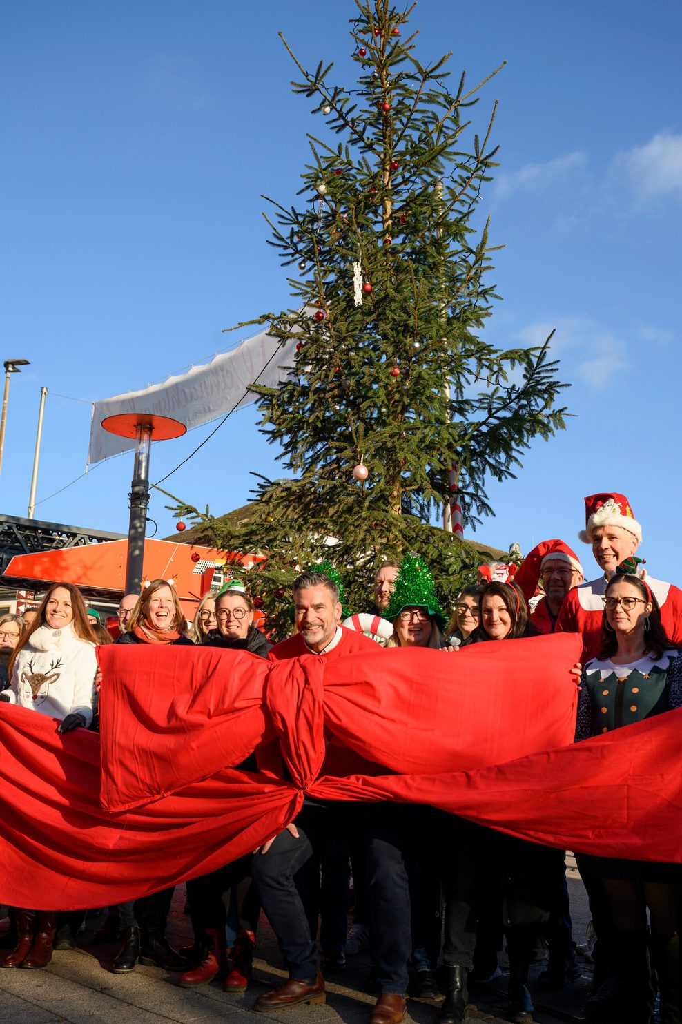 Bürgermeister Christian Belke (M., parteilos) und Bürger der Stadt Holzminden vor dem „Little Ugly Christmas Tree“.