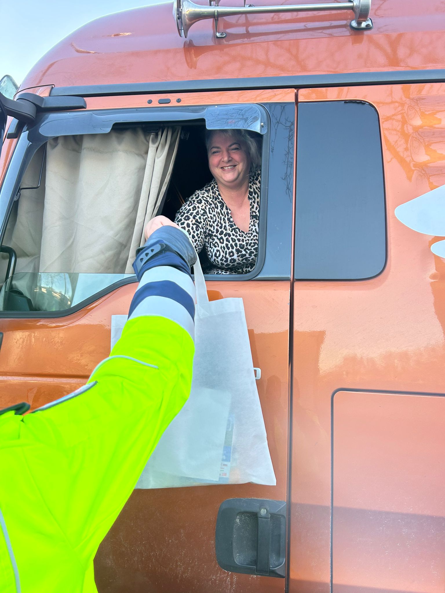 Eine Lkw-Fahrerin freut sich über die kleine Aufmerksamkeit bei der Geschenk-Aktion für Trucker an der A1.