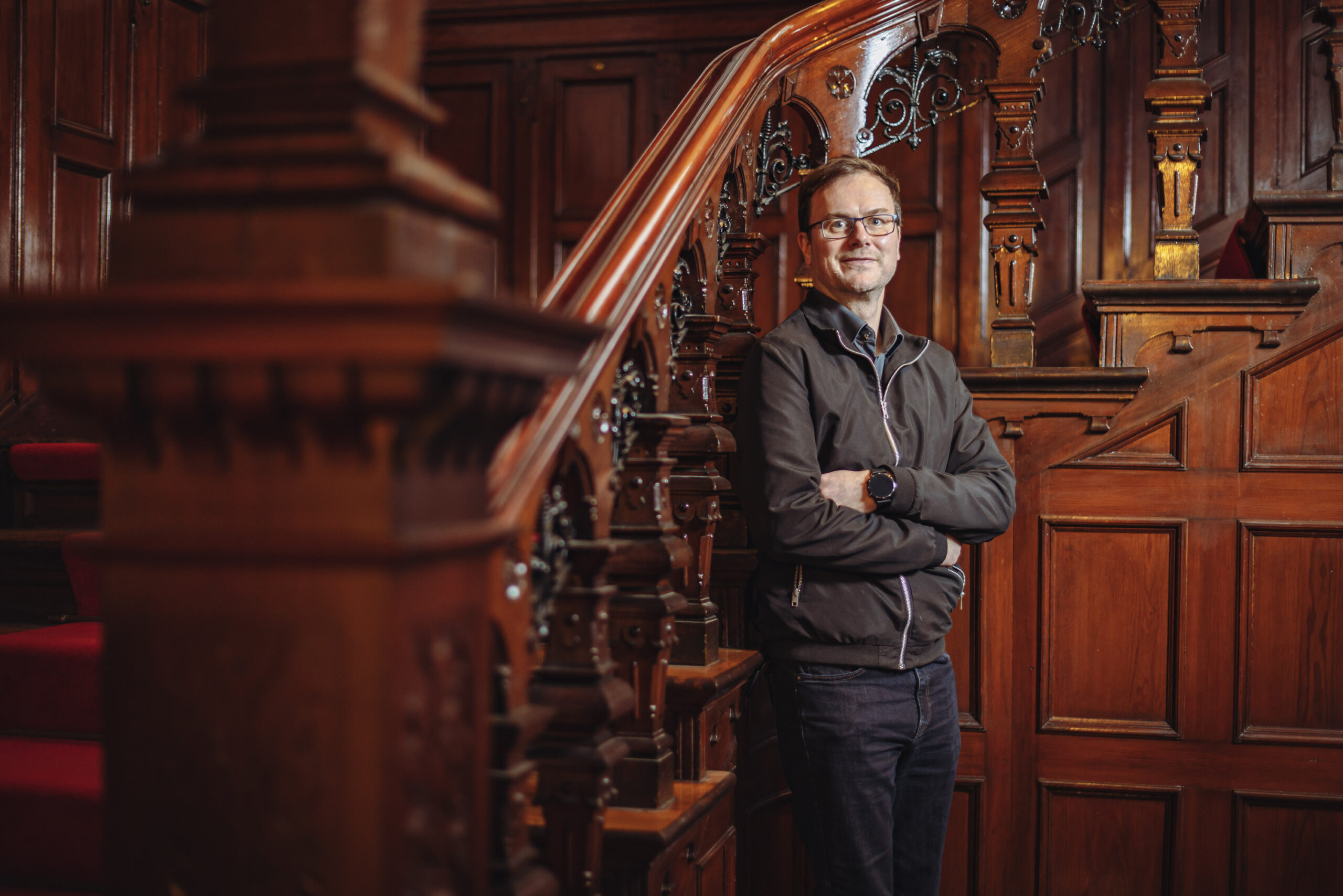 Sebastian Kloth steht in vertäfeltem Treppenhaus