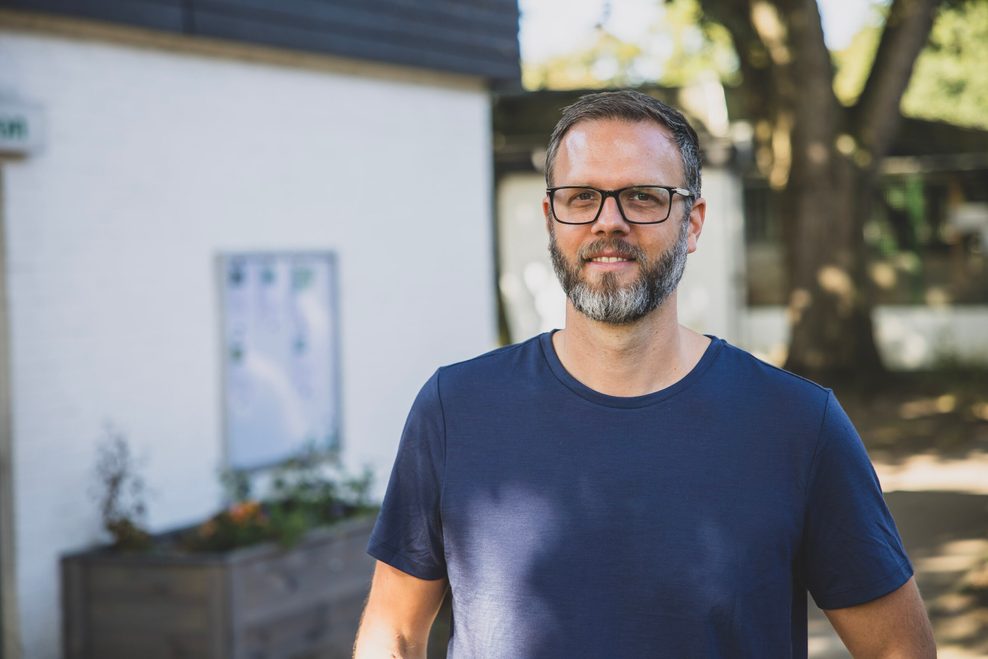 Junger Mann mit Bart und blauem T-Shirt