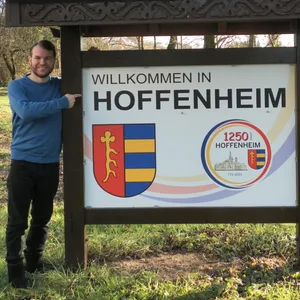 MOPO-Redakteur Robin Meyer vor dem Ortsschild von Hoffenheim