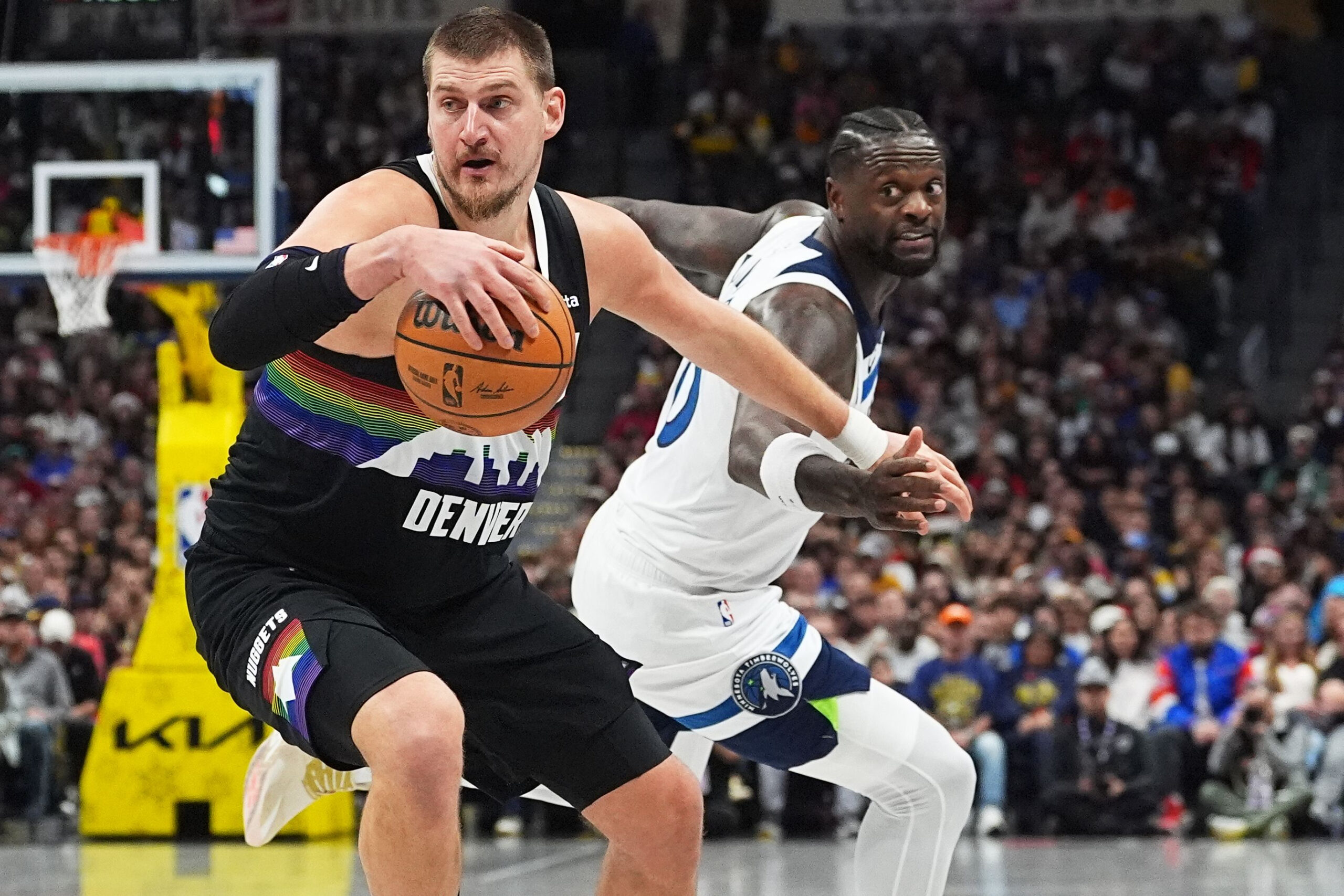 Denver Nuggets-Center Nikola Jokic dribbelt an Minnesota Timberwolves-Center Julius Randle vorbei