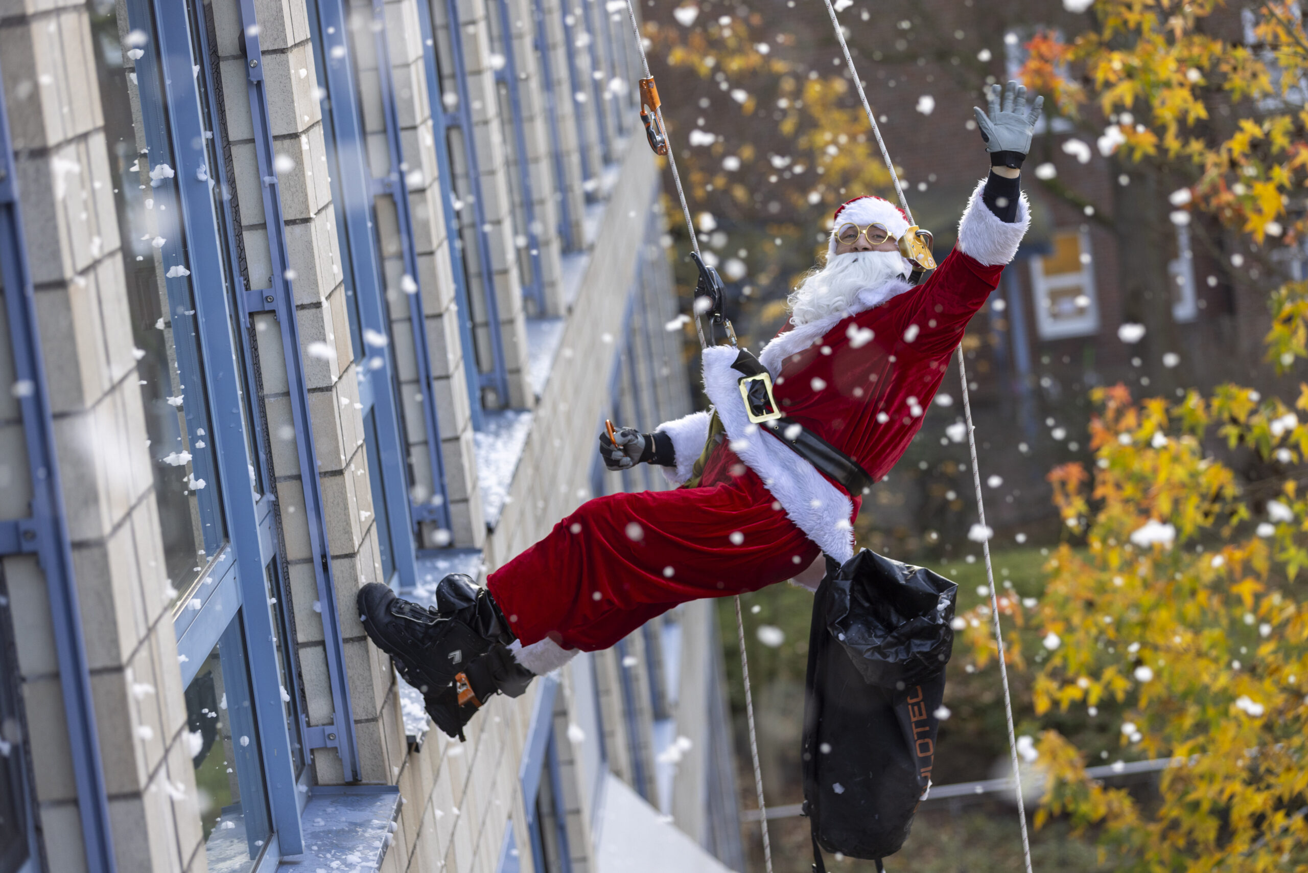Der Weihnachtsmann seilt sich mit einem Sack voller Geschenke an der Fassade der Schön-Kliniken in Hamburg-Eilbek ab.