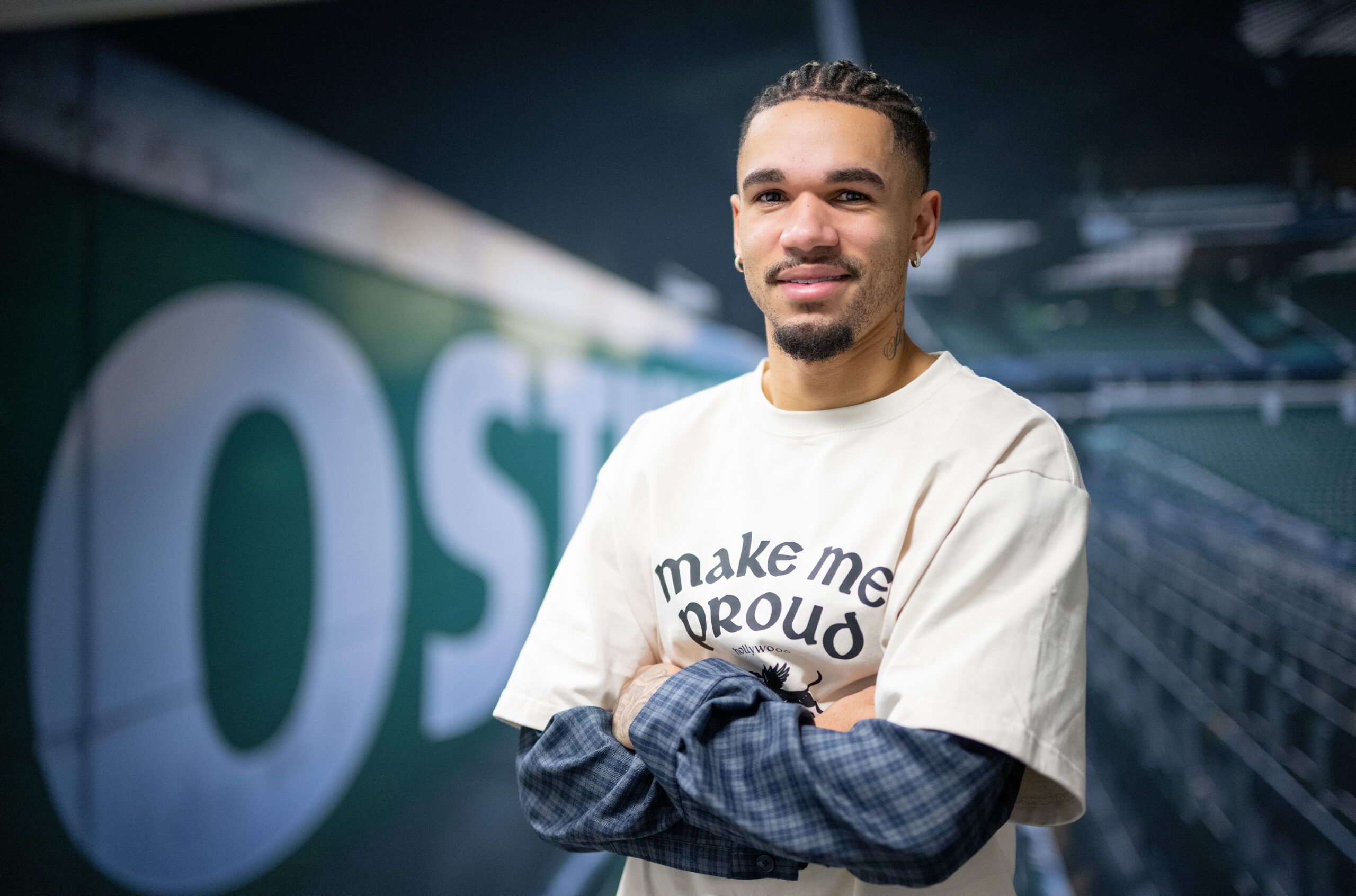 Justin Njinmah verschränkt die Arme bei einem Fotoshooting
