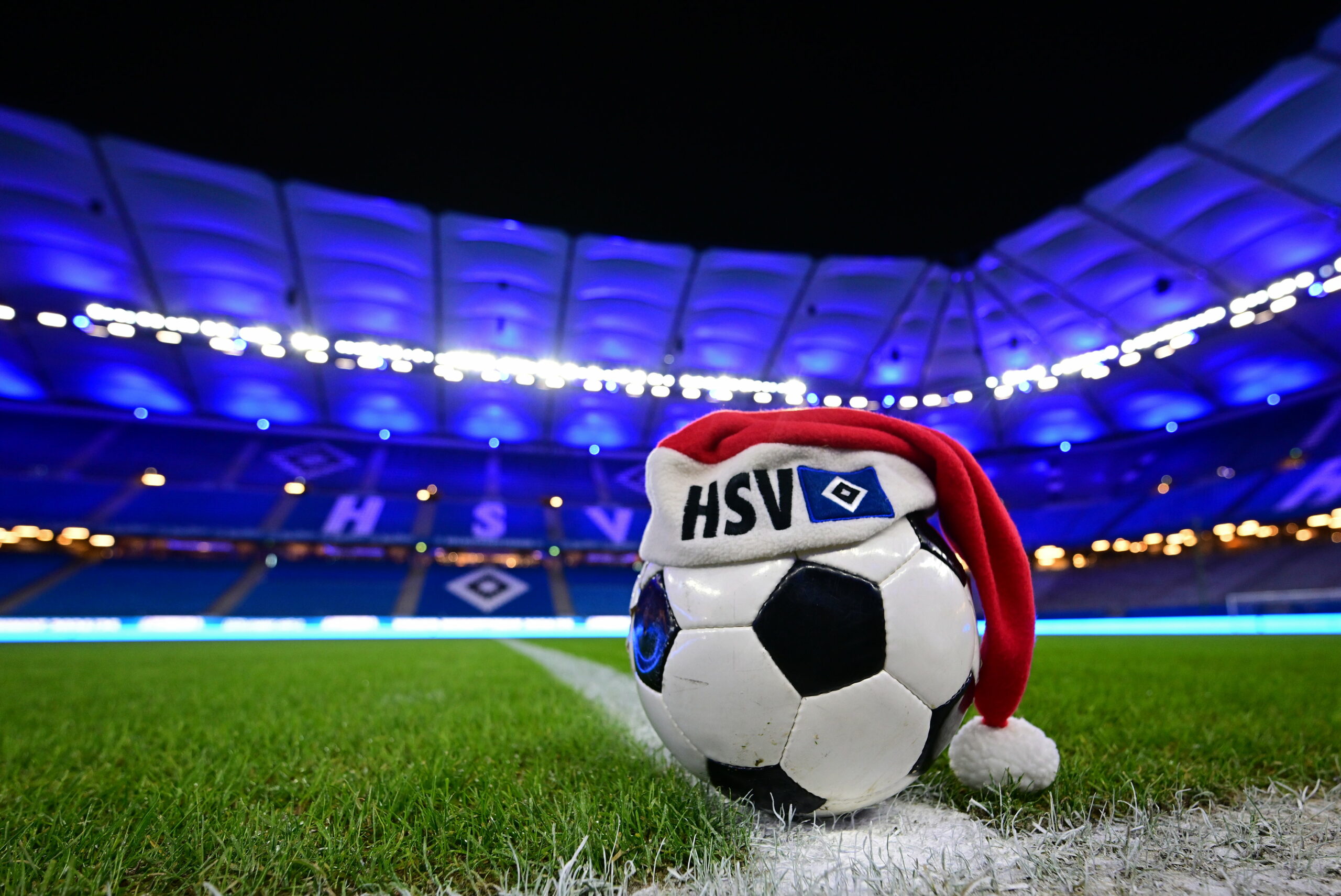 Ein Fußball mit Weihnachtsmütze auf dem Rasen des Volksparkstadions