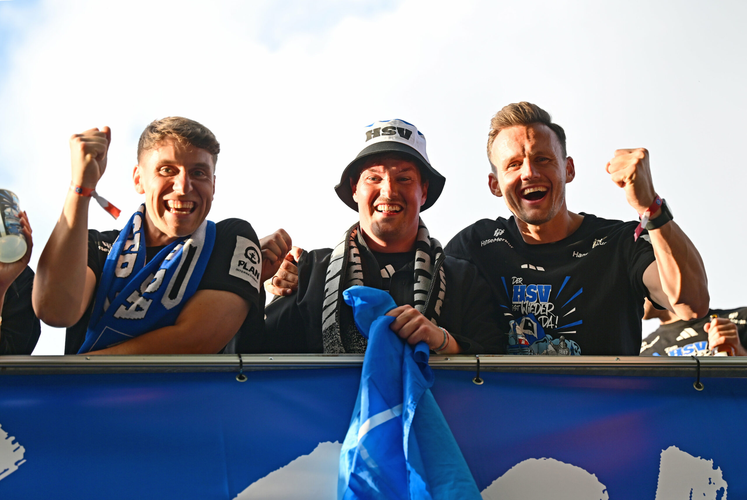 Loic Favé, Merlin Polzin und Claus Costa jubeln auf einem Bus