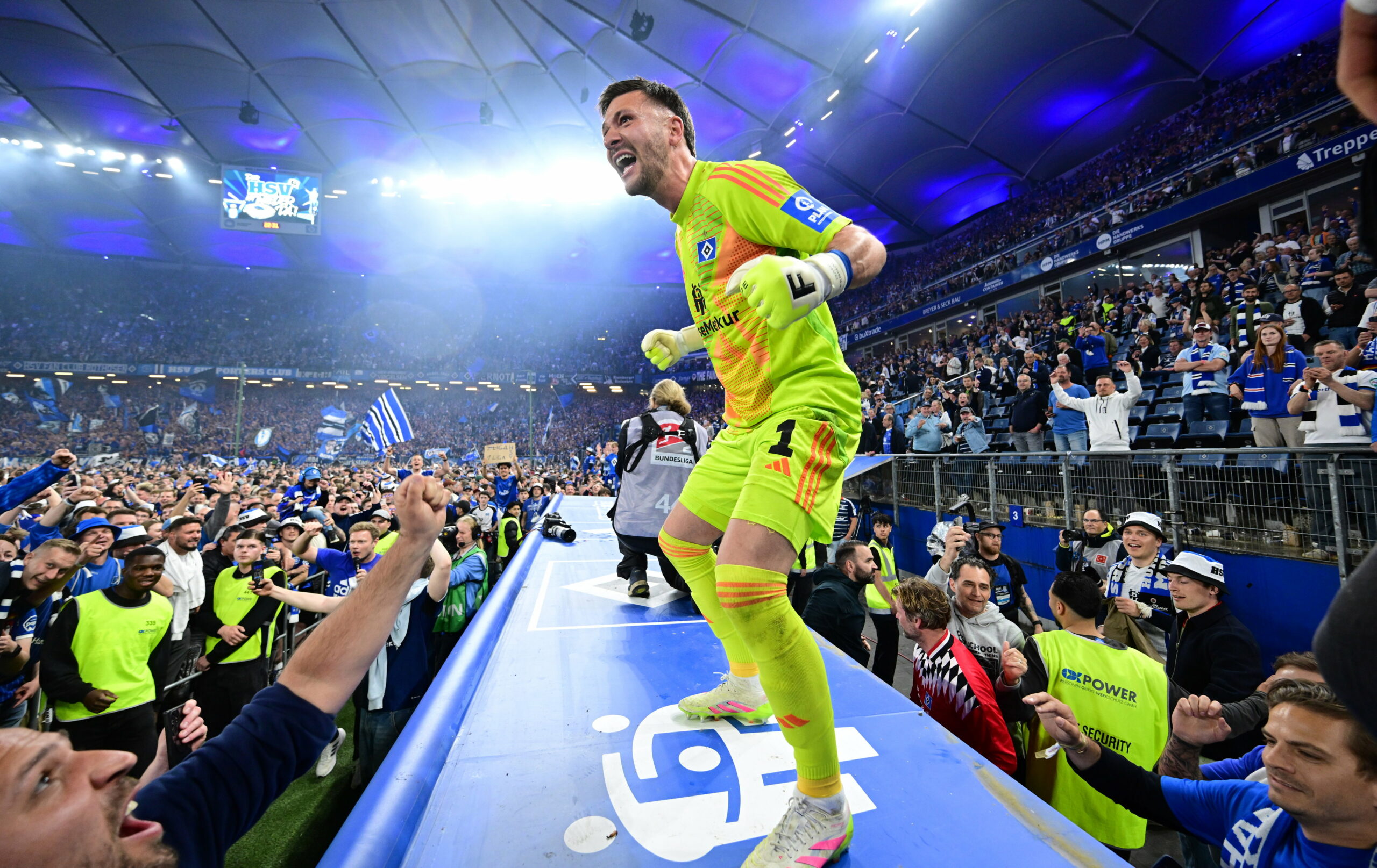 Daniel Heuer Fernandes steht auf dem Dach der Auswechselbank und jubelt