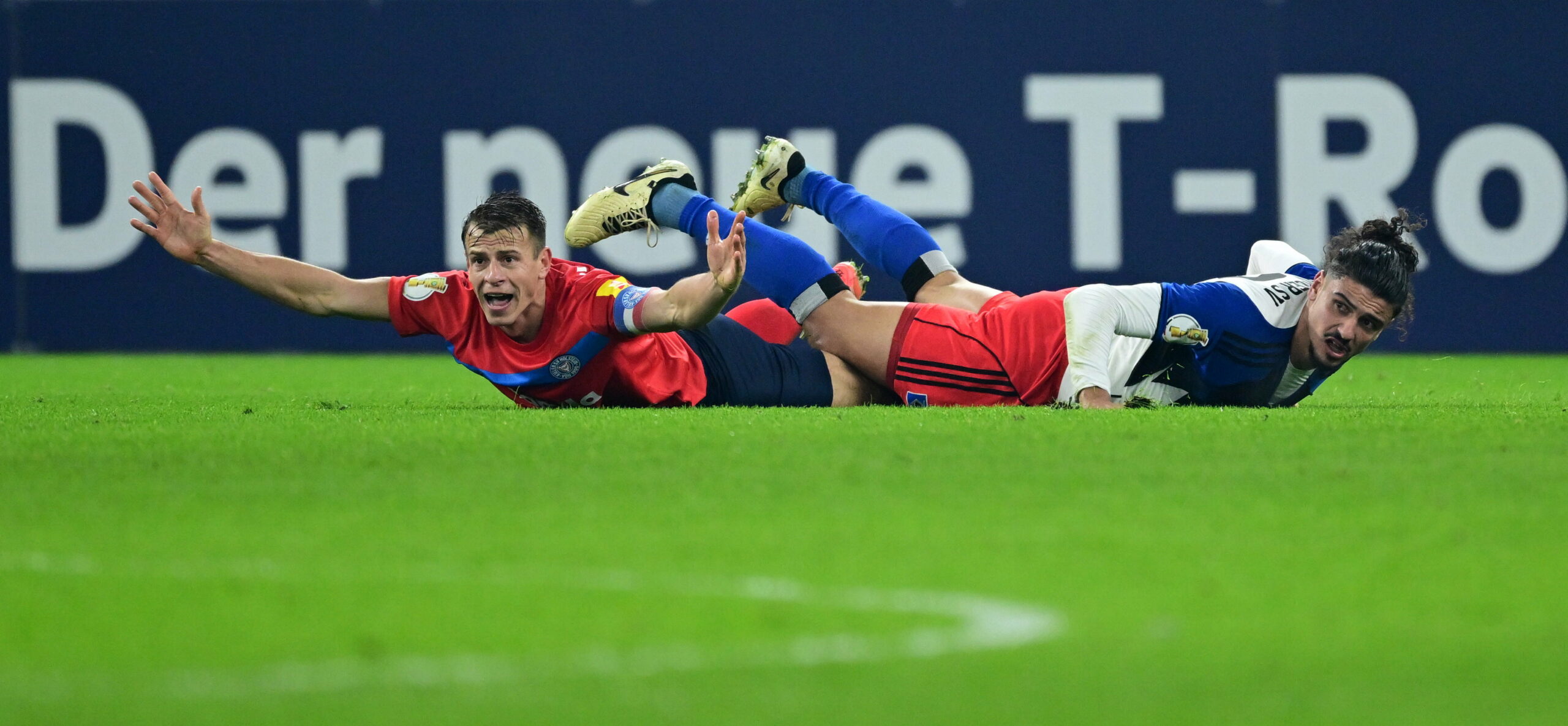Stefan Schwab und Guilherme Ramos liegen nebeneinander auf dem Rasen