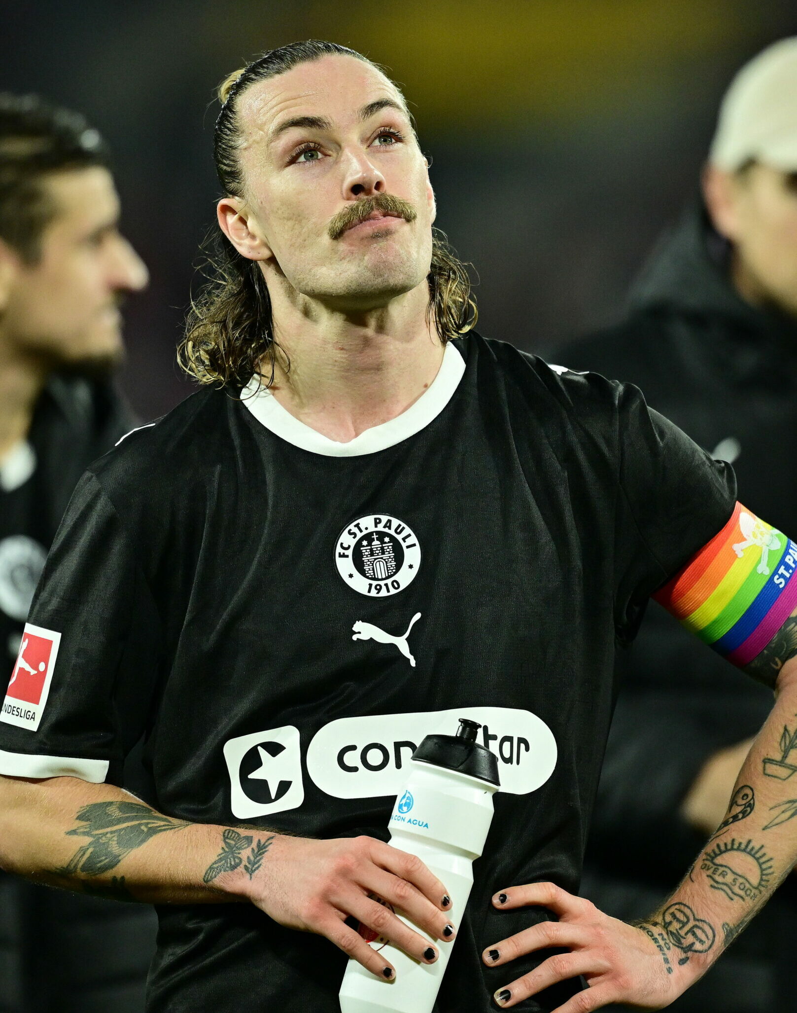 Jackson Irvine hält eine Trinkflasche und sieht erschöpft aus