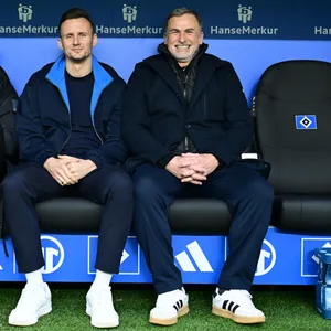 Eric Huwer, Claus Costa und Stefan Kuntz lächeln nebeneinander auf der Auswechselbank