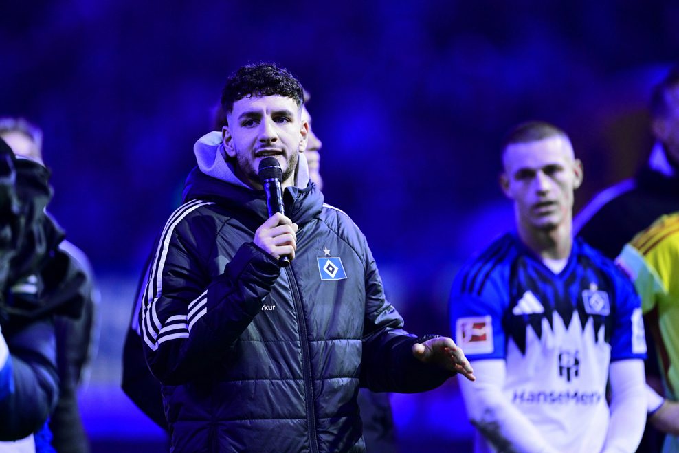 Daniel Elfadli spricht mit dem Mikrofon in der Hand zu den HSV-Fans.
