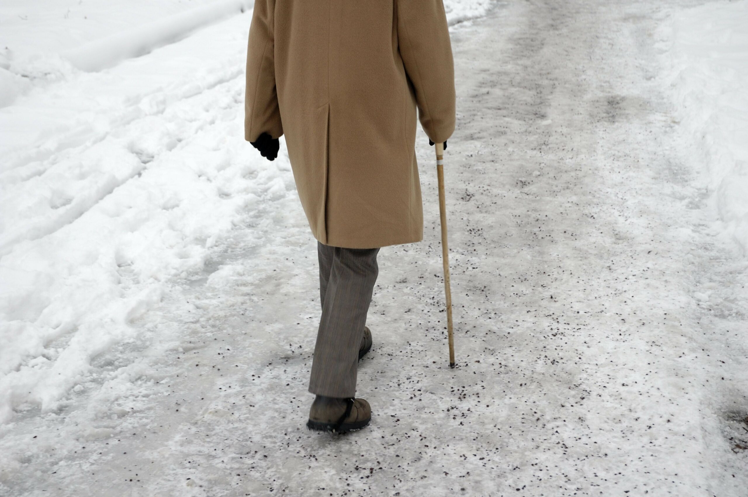 Gefahr durch Glatteis! Ein älterer Mann läuft über einen vereisten Gehweg. (Symbolbild)