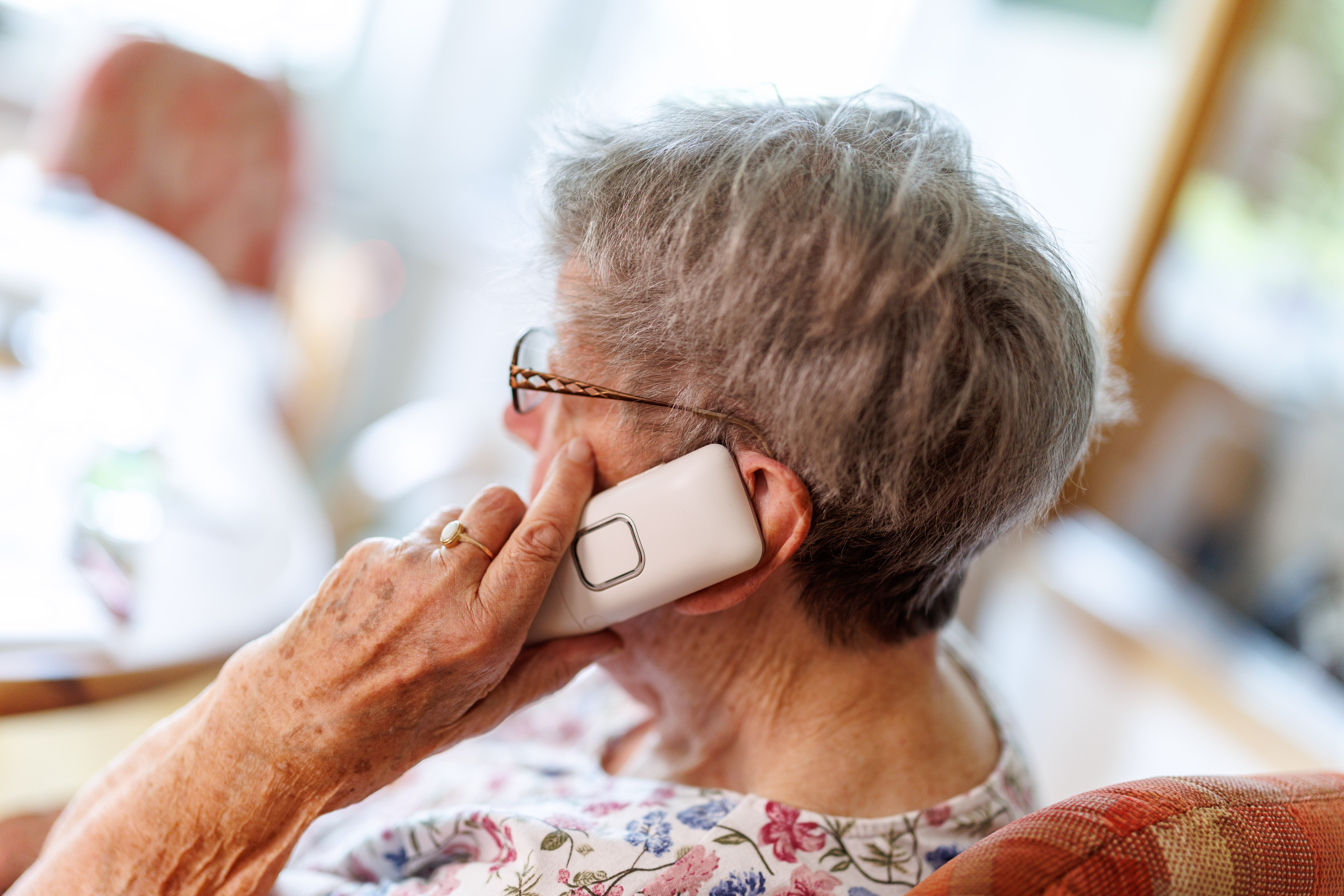 Ältere Dame telefoniert mit ihrem Telefon