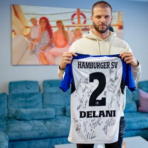 Dennis Diekmeier hält ein HSV-Trikot mit dem Namen seiner Tochter Delani hoch