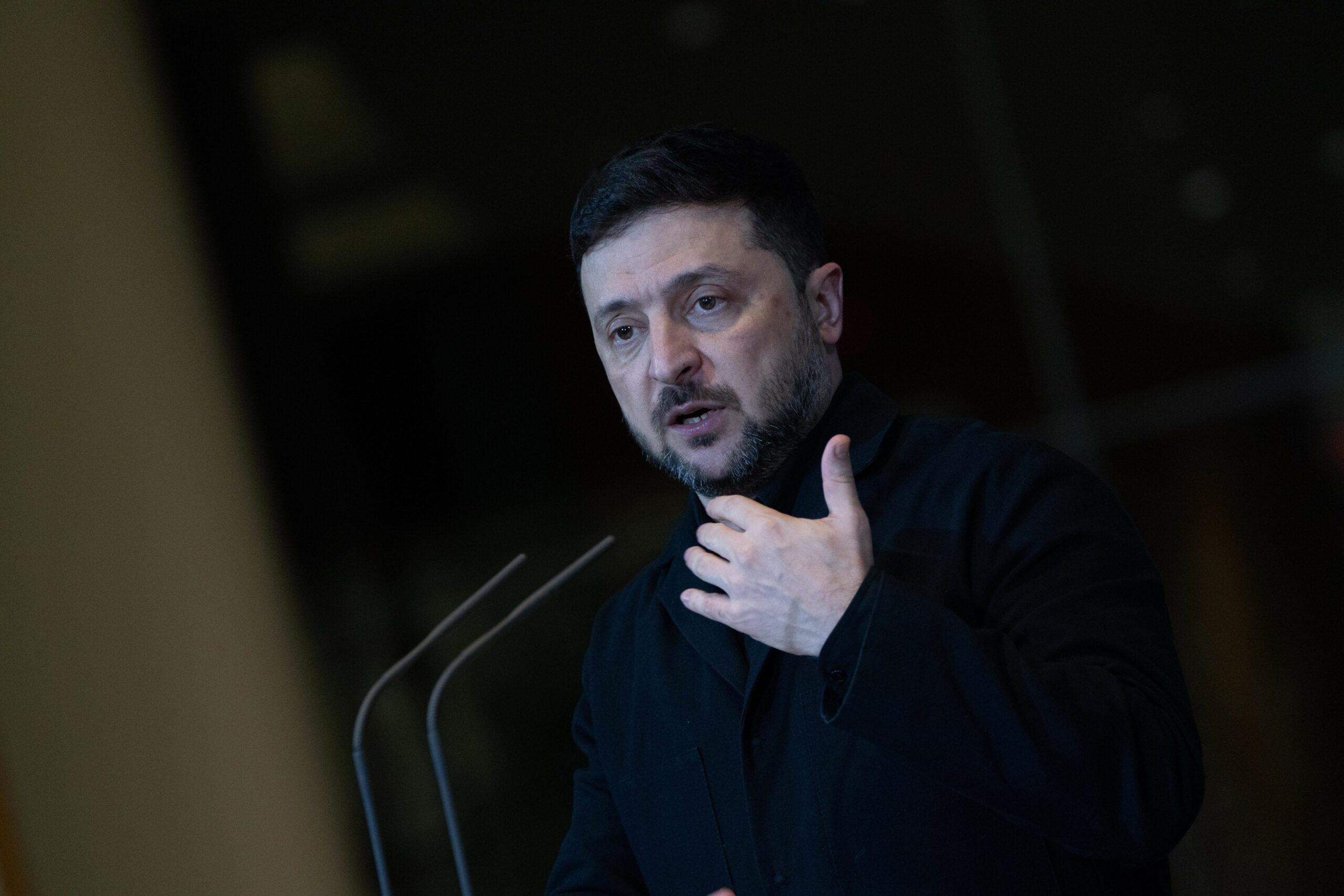 Mann in schwarzem Rollkragenpullover an Mikrofon