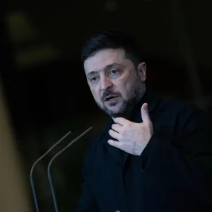 Mann in schwarzem Rollkragenpullover an Mikrofon