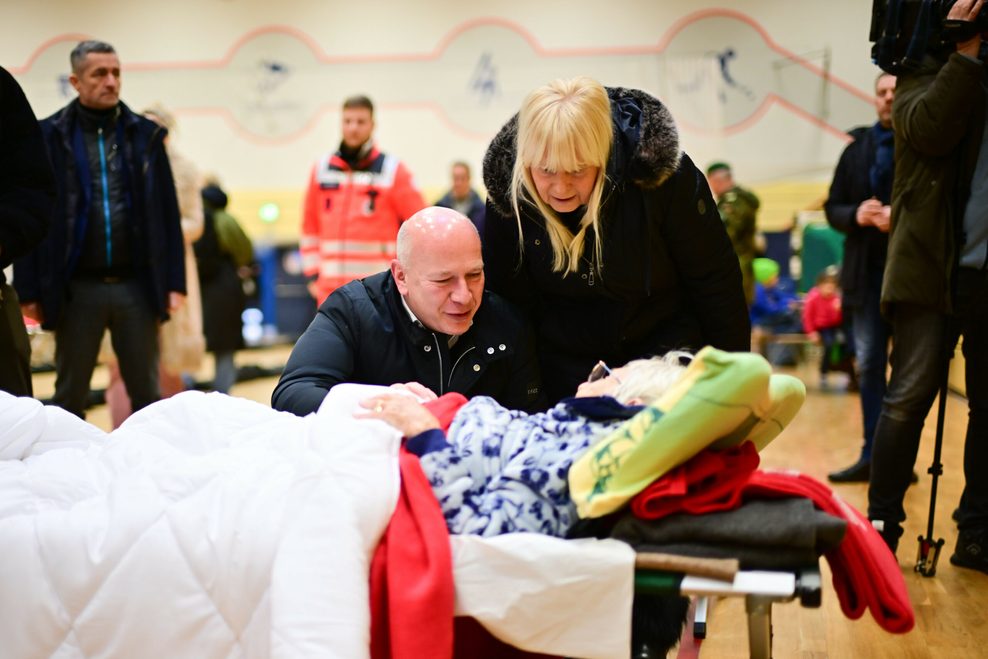 Kai Wegner (CDU), Regierender Bürgermeister von Berlin, und Iris Spranger (SPD), Berliner Innensenatorin, sprechen während eines Stromausfalls im Südwesten Berlins in einer Notunterkunft mit einer 97-jährigen.