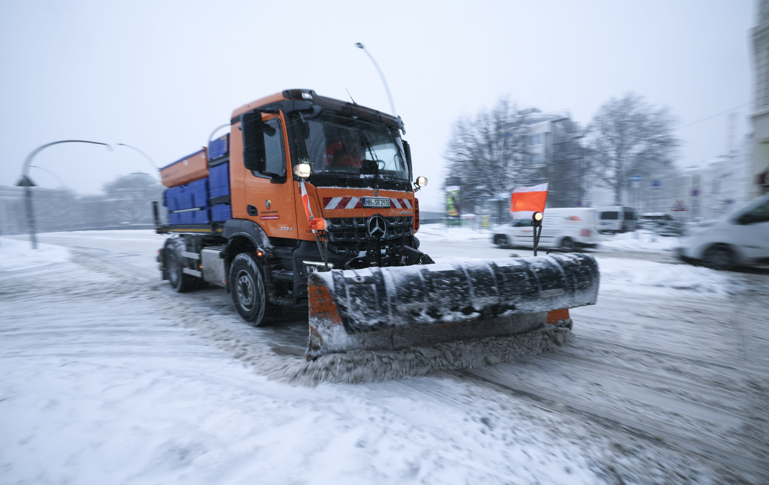 Ein Räum-und Streufahrzeug der Stadtreinigung Hamburg schiebt Schnee von einer Straße am Hauptbahnhof.