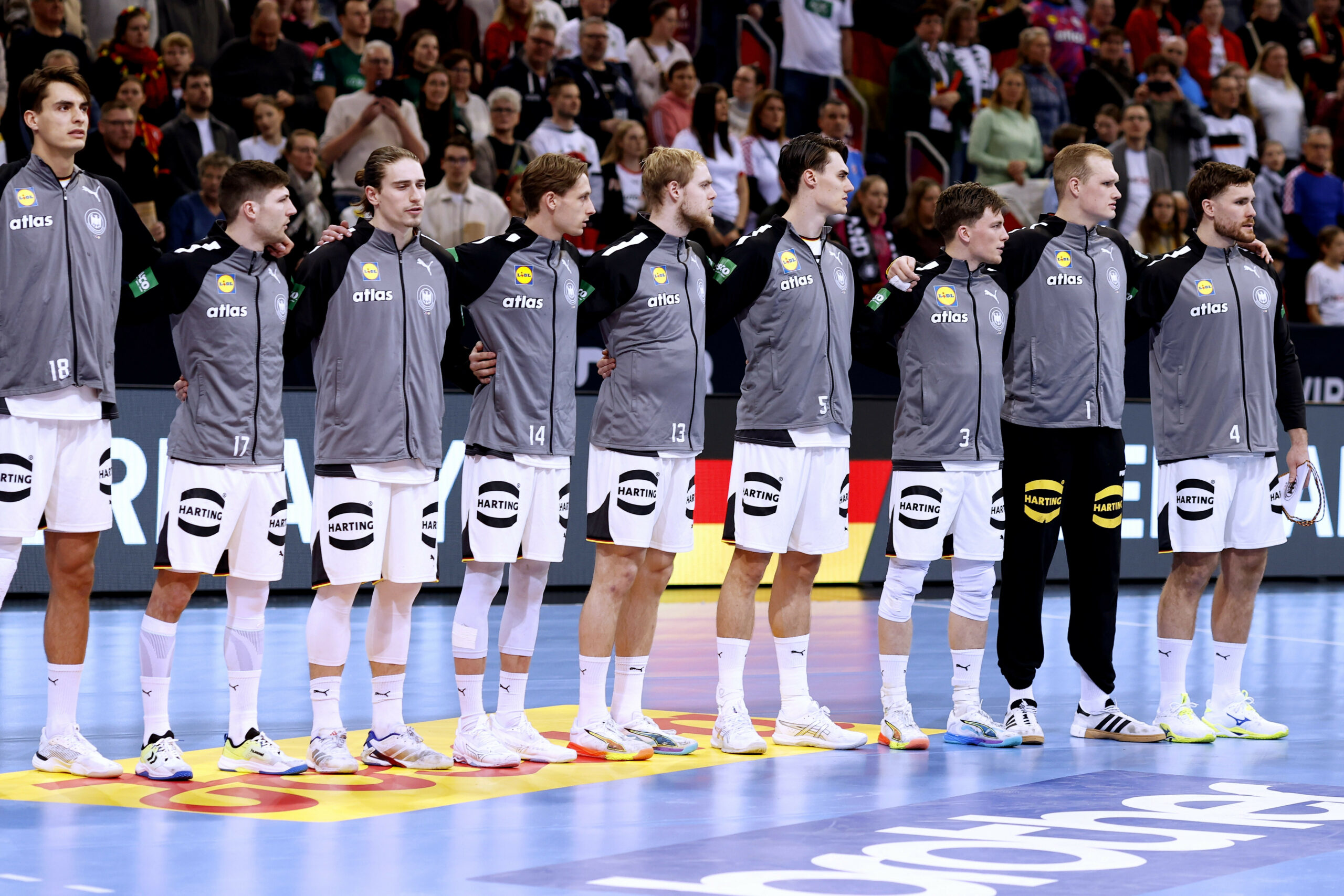 Deutschlands Handballer stehen Arm in Arm und singen die Hymne