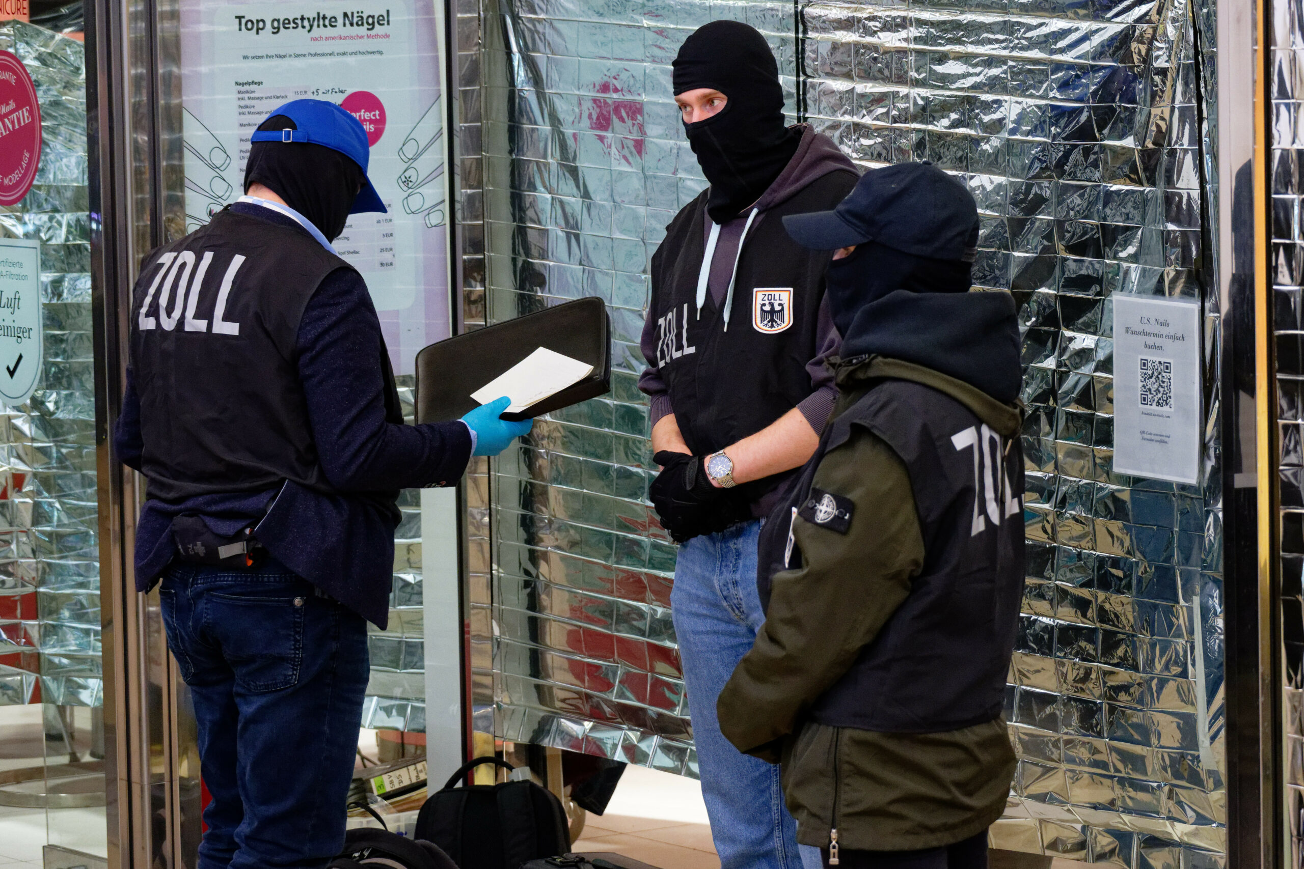 Zollbeamte durchsuchen ein Nagelstudio in Köln.