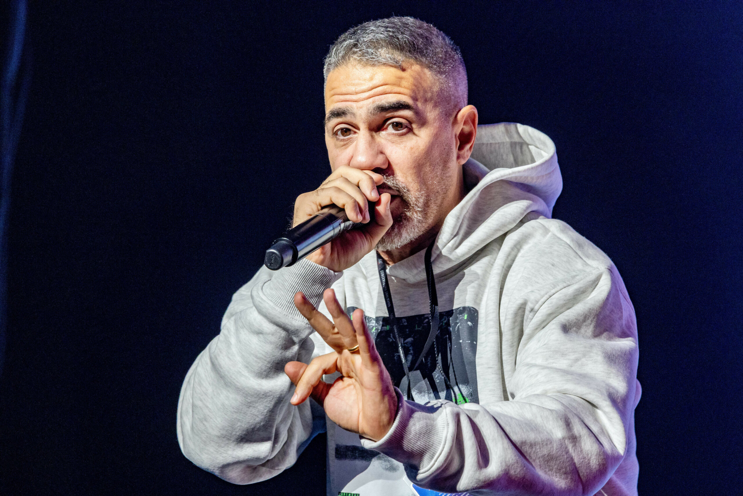 Mann im grauen Kapuzenpullover mit Mikro