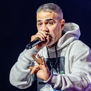 Mann im grauen Kapuzenpullover mit Mikro