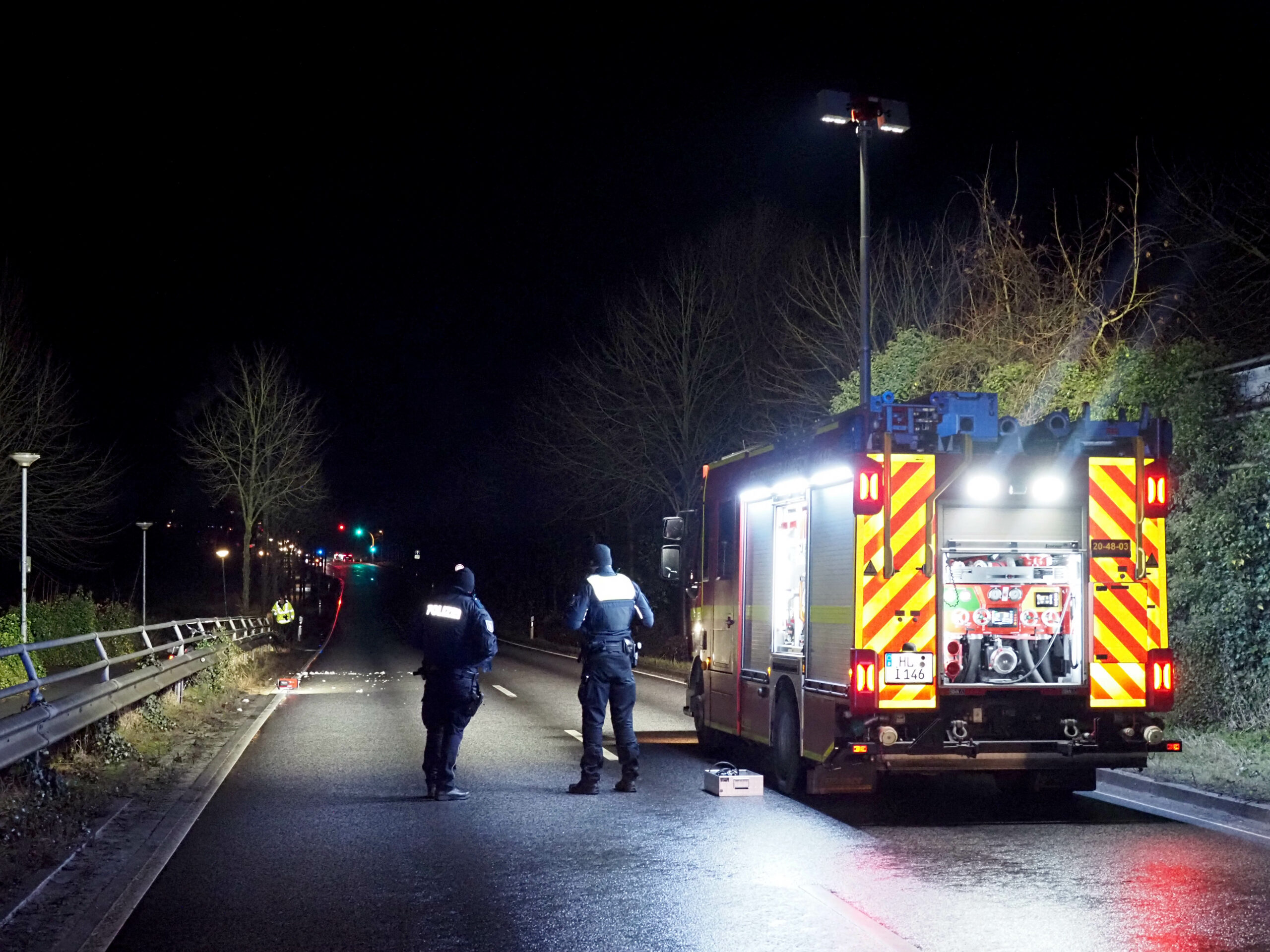 Die Feuerwehr leuchtet die Unglücksstelle auf der B207 in Lübeck für die Spurensicherung aus.