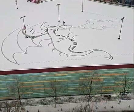 Aus dem Schnee schaut einem ein feuerspeiender Drache entgegen.