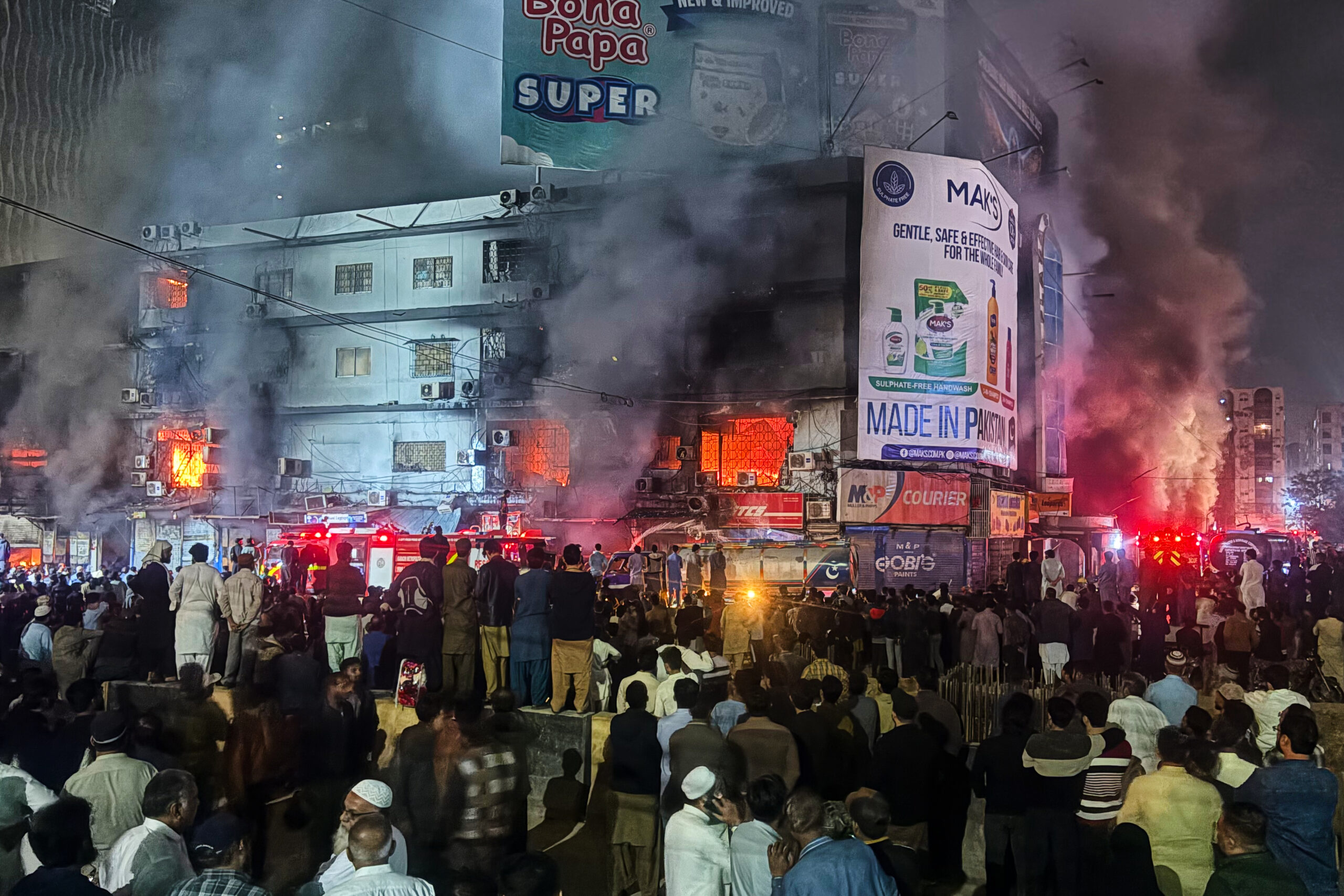 Flammen schlagen aus dem Einkaufszentrum in Karachi, während Feuerwehrleute versuchen, den Großbrand unter Kontrolle zu bringen.