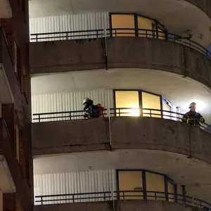 Feuerwehrkräfte durchsuchen das Hochhaus.