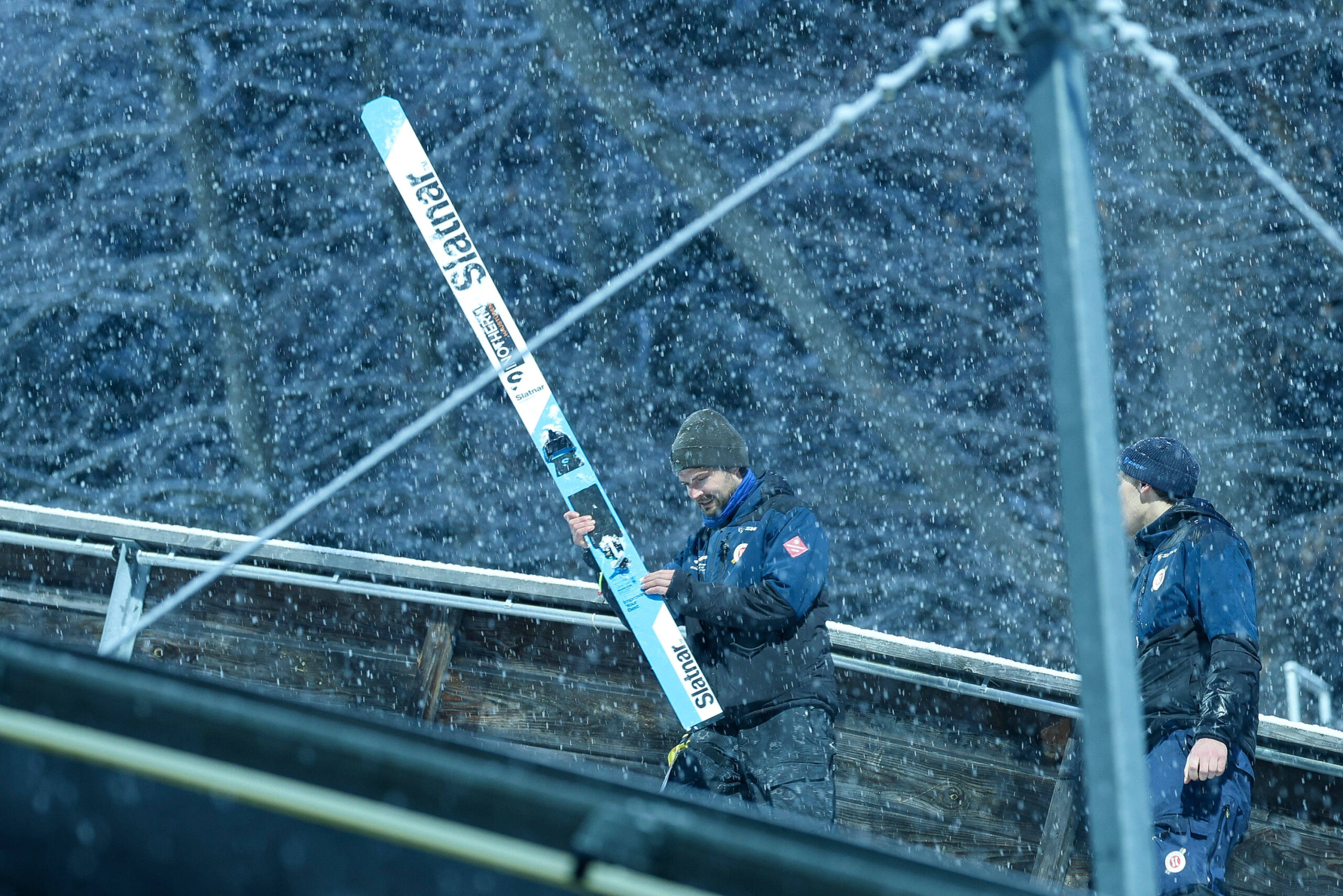 Ein Offizieller mit einem Ski von Domen Prevc