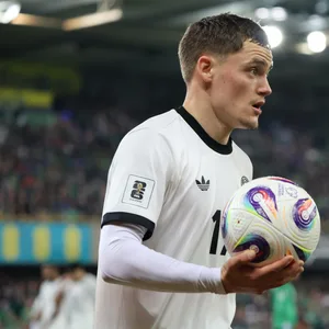 Florian Wirtz hält einen Fußball in der rechten Hand und guckt entschlossen.