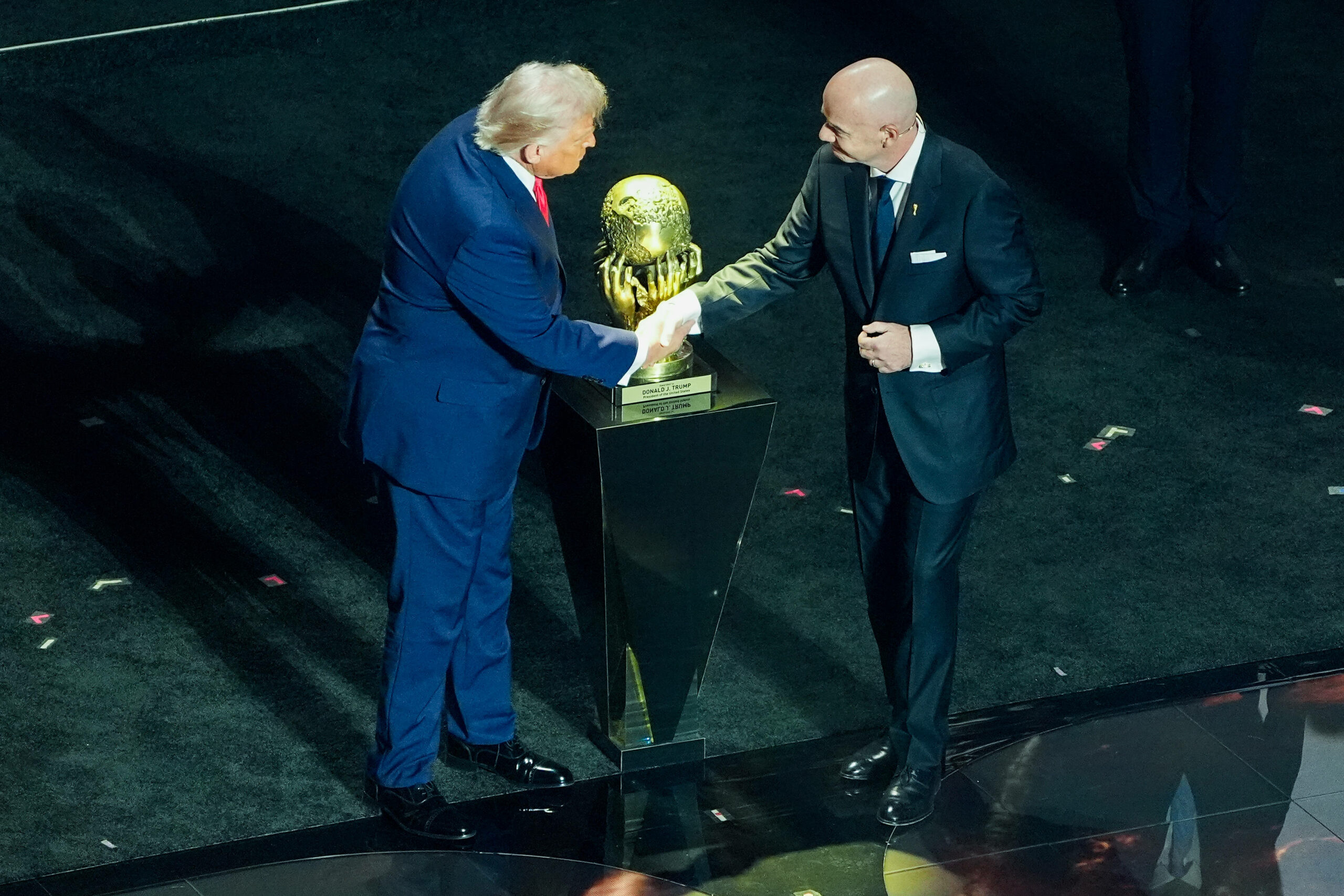 Donald Trump und Gianni Infantino schütteln ihre Hände vor dem WM-Pokal