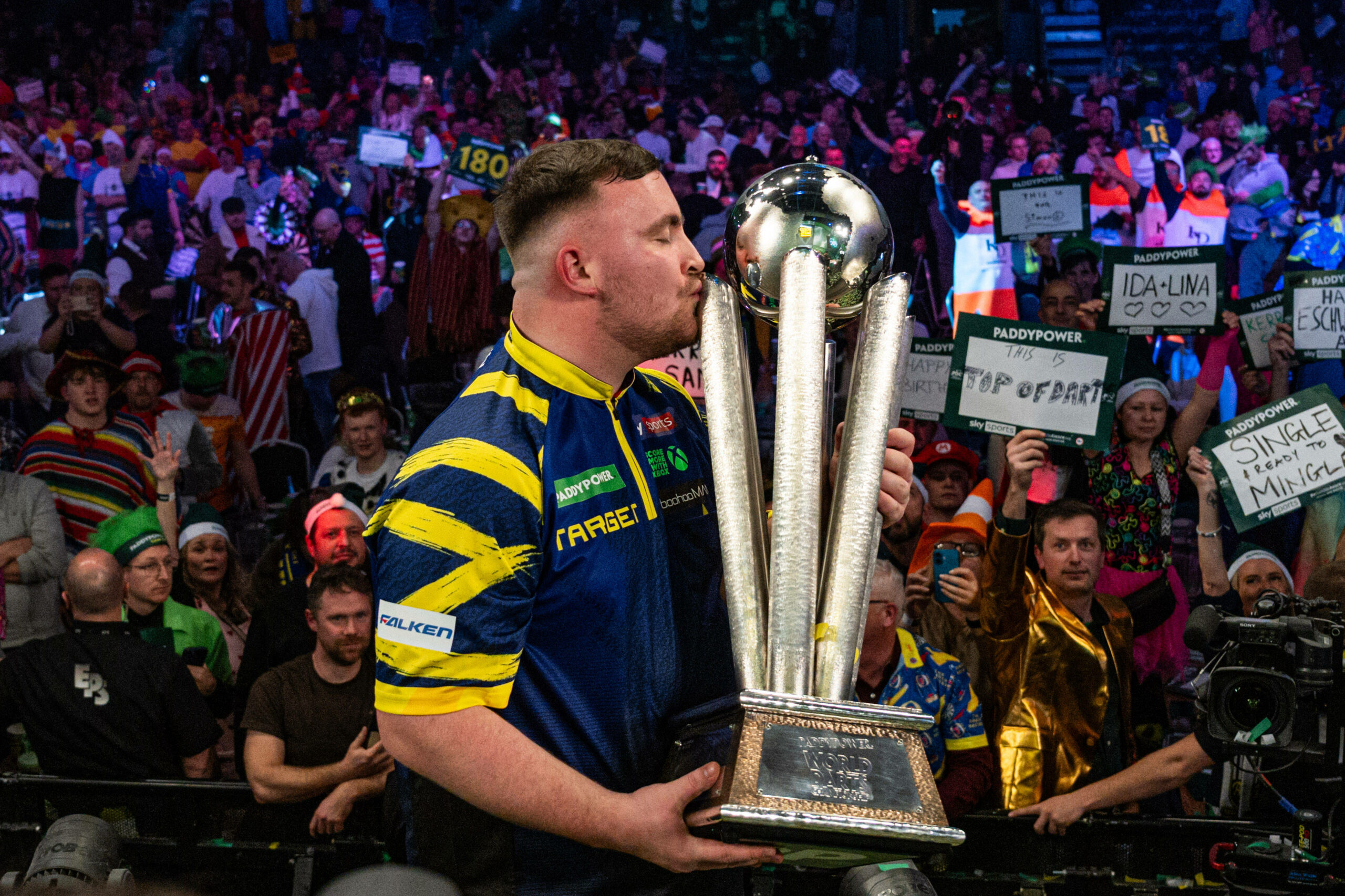 Luke Littler küsst die WM-Trophäe