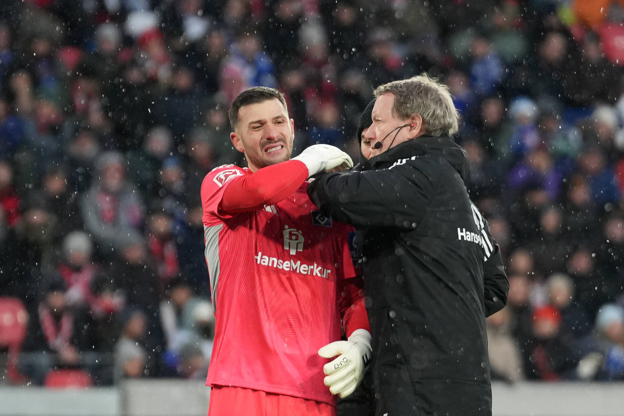 HSV-Torwart Daniel Heuer fernandes (l.) wird in Freiburg von Teamarzt Götz Welsch behandelt.