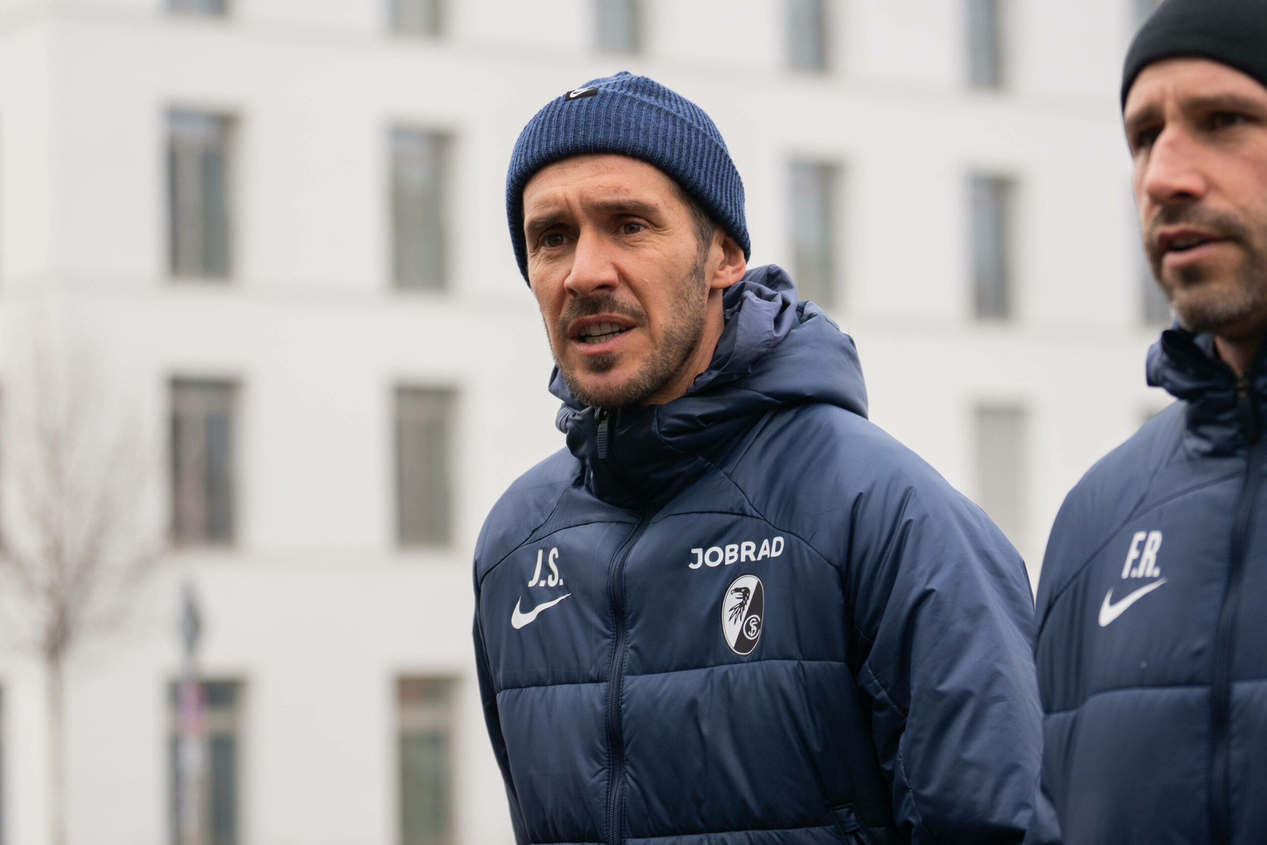 Julian Schuster mit Mütze auf dem Weg zum Trainingsplatz.