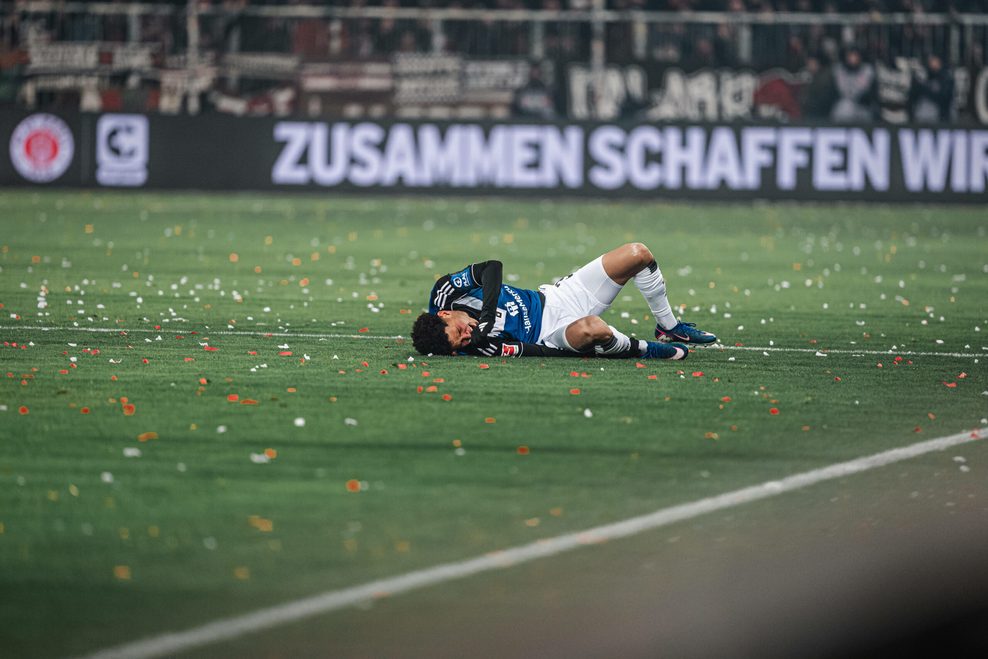 Alexander Røssing-Lelesiit liegt auf dem Spielfeld und krümmt sich vor Schmerzen