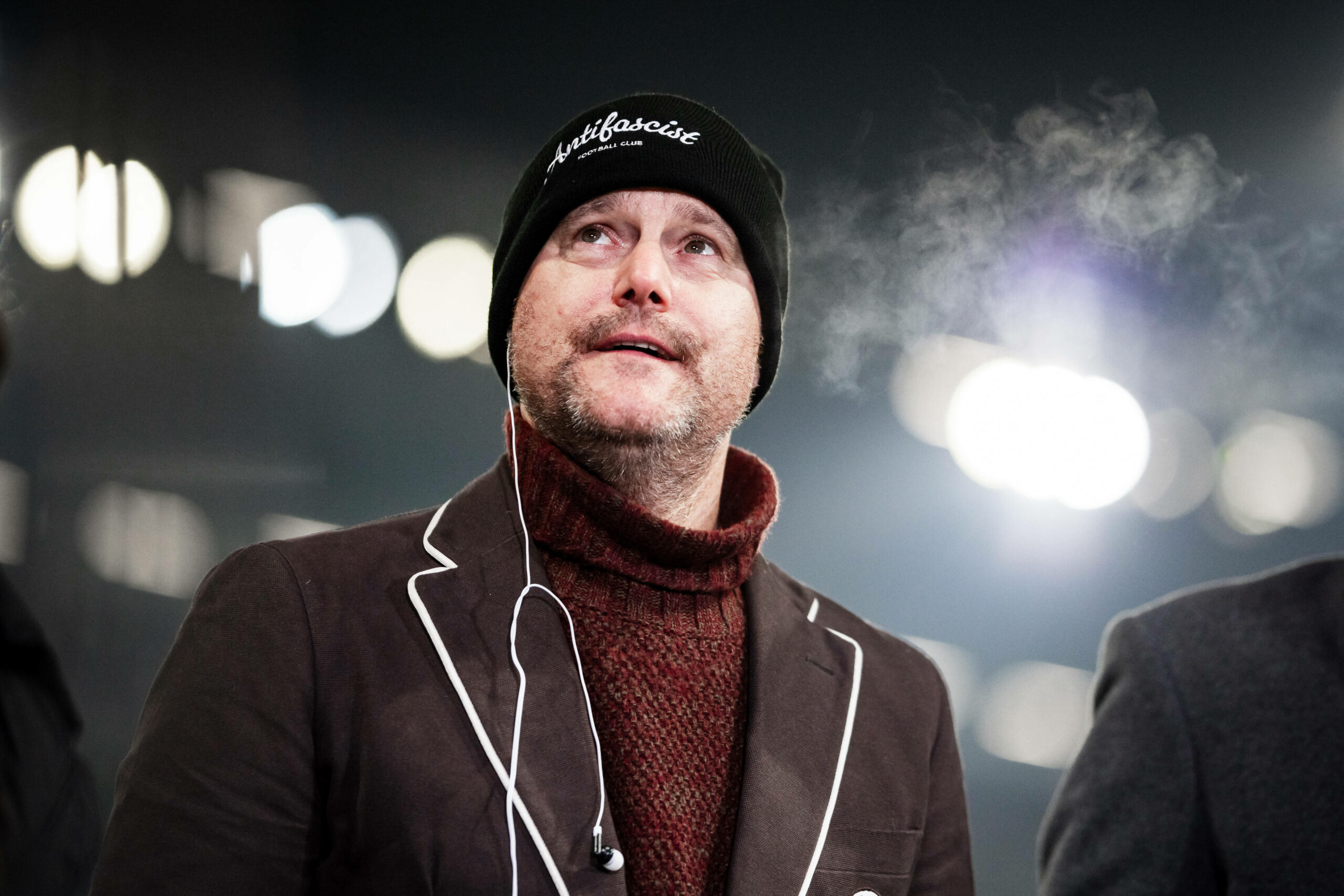 Oke Göttlich guckt mit Mütze auf dem Kopf in die Ferne.