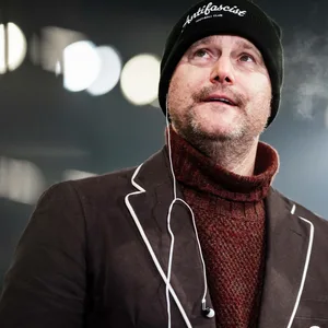 Oke Göttlich guckt mit Mütze auf dem Kopf in die Ferne.