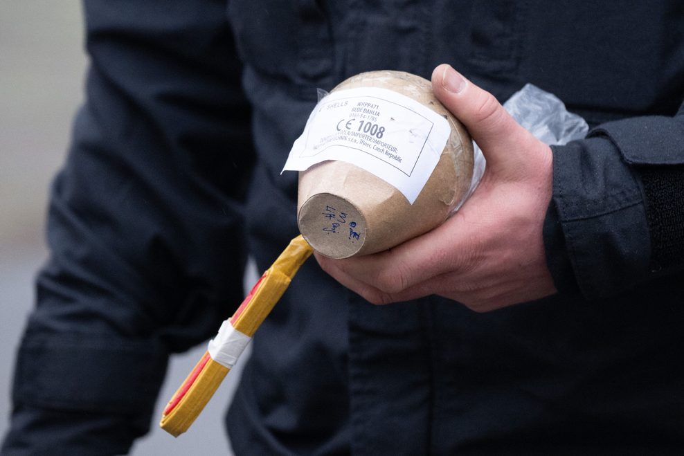 eine Kugelbombe in der Hand eines Polizisten