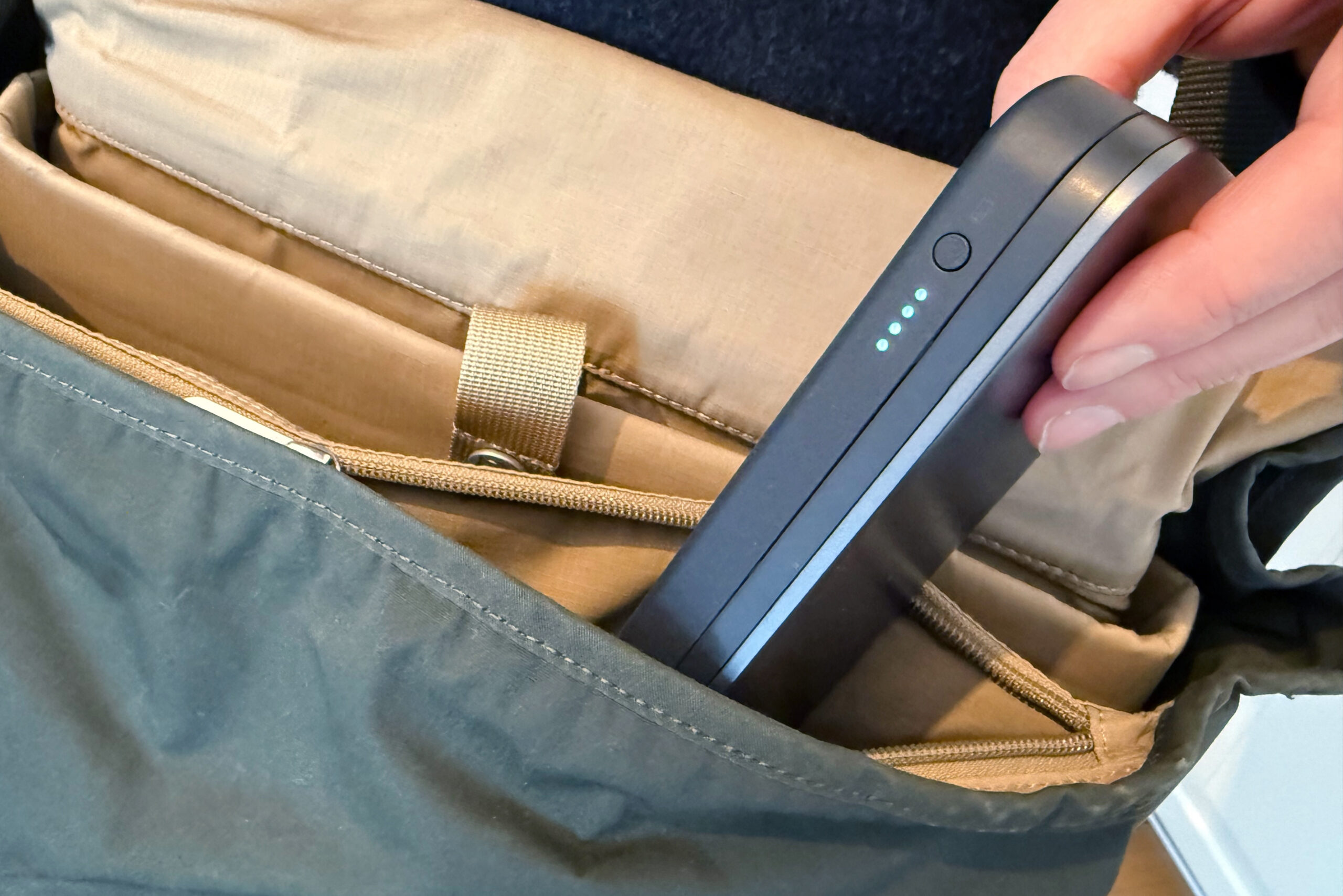 Mann steckt eine Powerbank in seinen Rucksack.