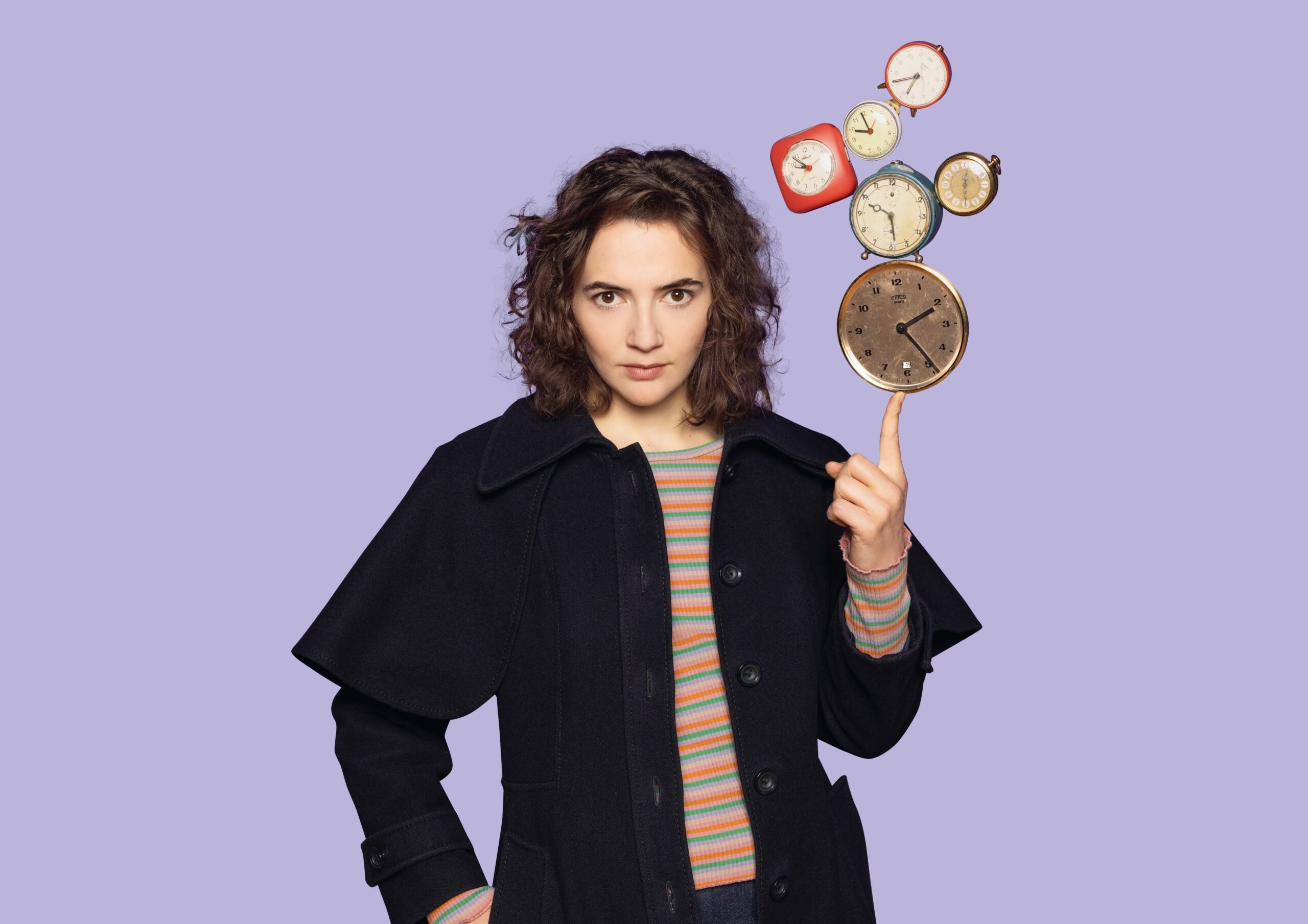 Eine junge Frau balanciert auf ihrem ausgestreckten Zeigefinger mehrere Uhren.