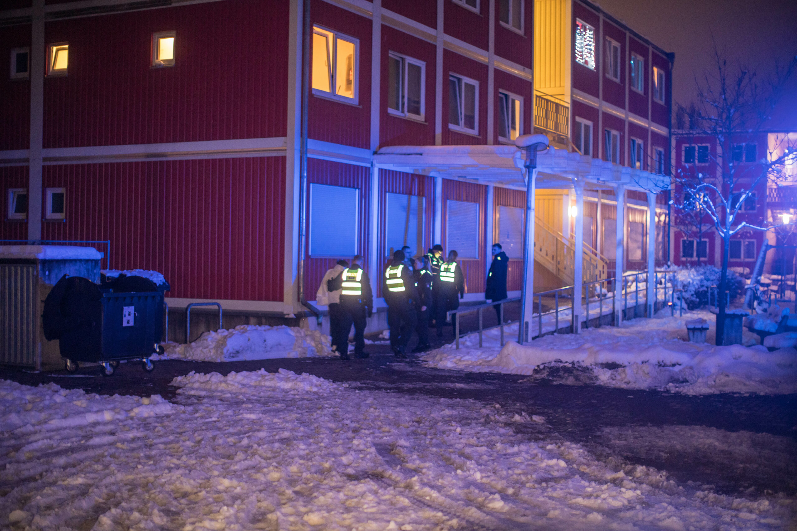 Polizisten stehen vor der Unterkunft an der Schlenzigstraße in Wilhelmsburg.