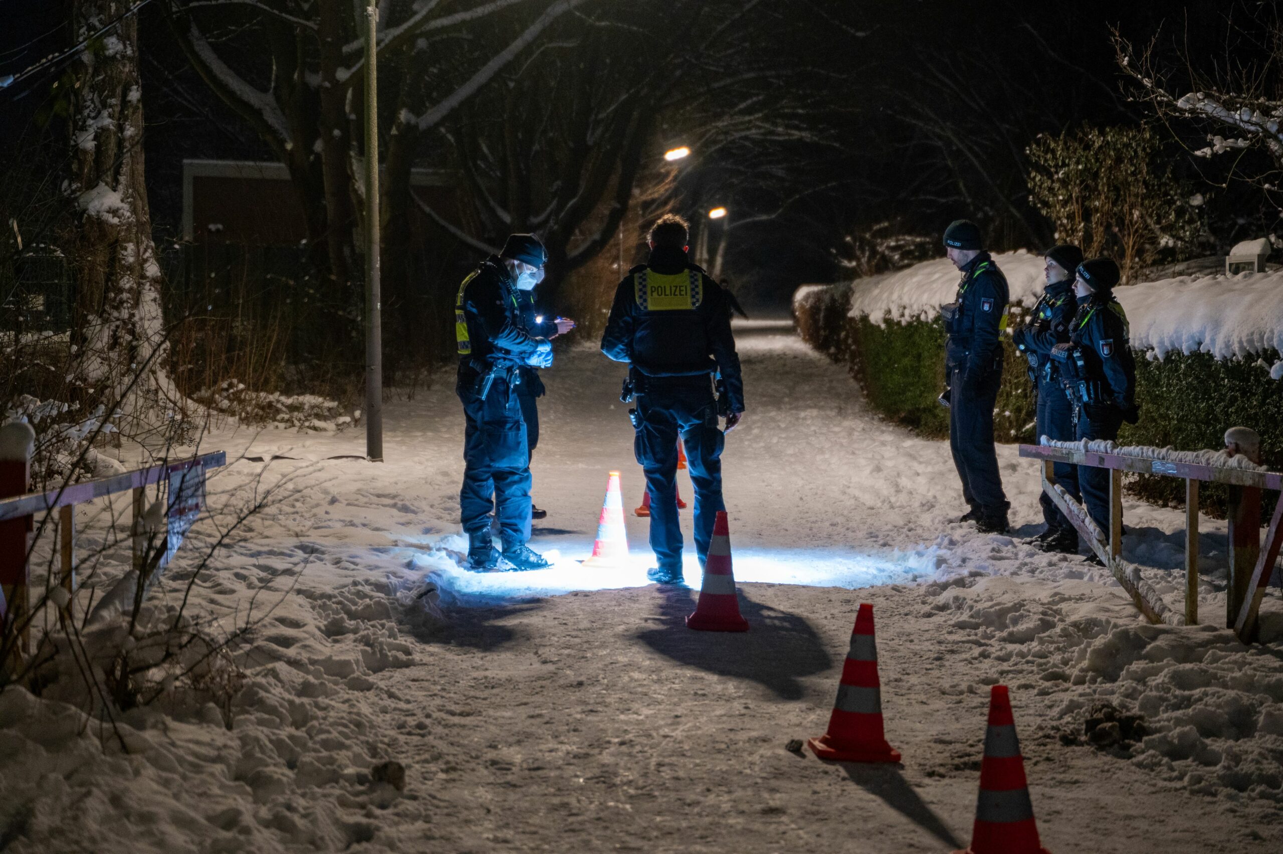 Polizeikräfte nahe dem Tatort in Billstedt: Eine Blutspur führt von der Kneipe auf die Straße.