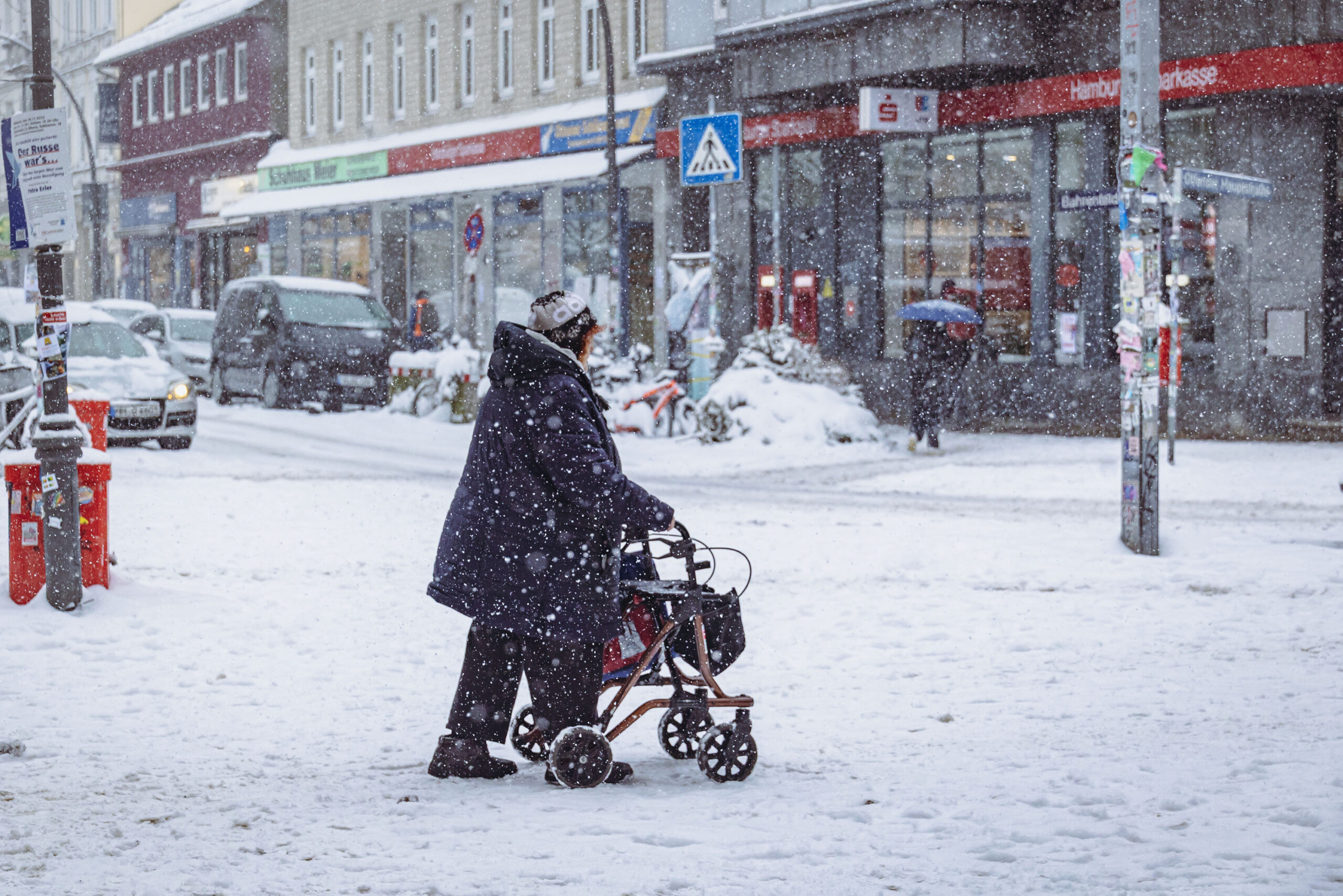 Frau mit Rollator bei Schneefall