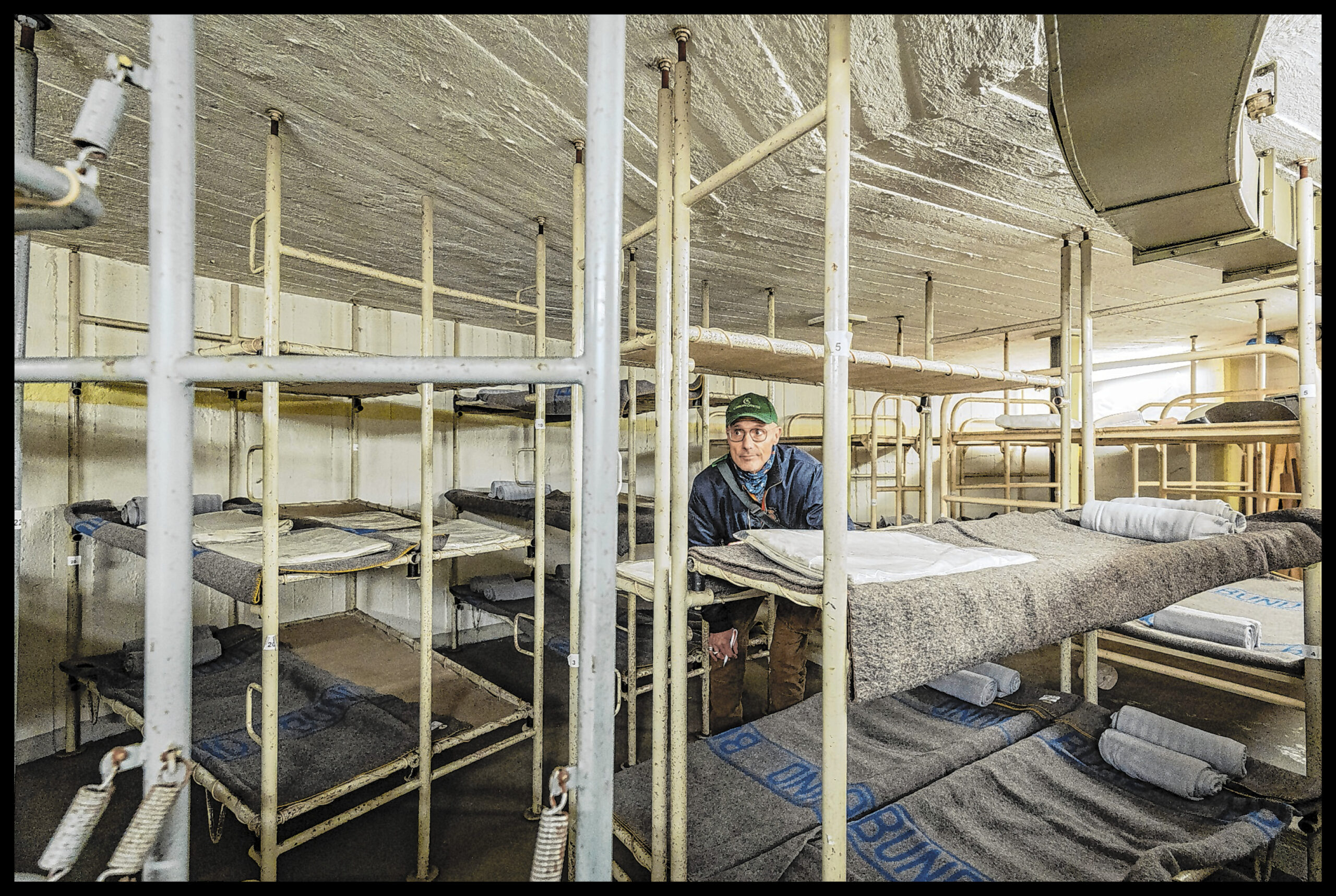 MOPO-Reporter Thomas Hirschbiegel in einem Schlafraum mit dreistöckigen Betten.