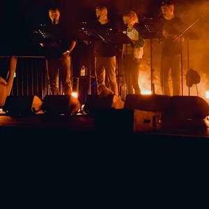 Vier Synchronsprecher stehen vor Mikrofonen auf der Bühne.